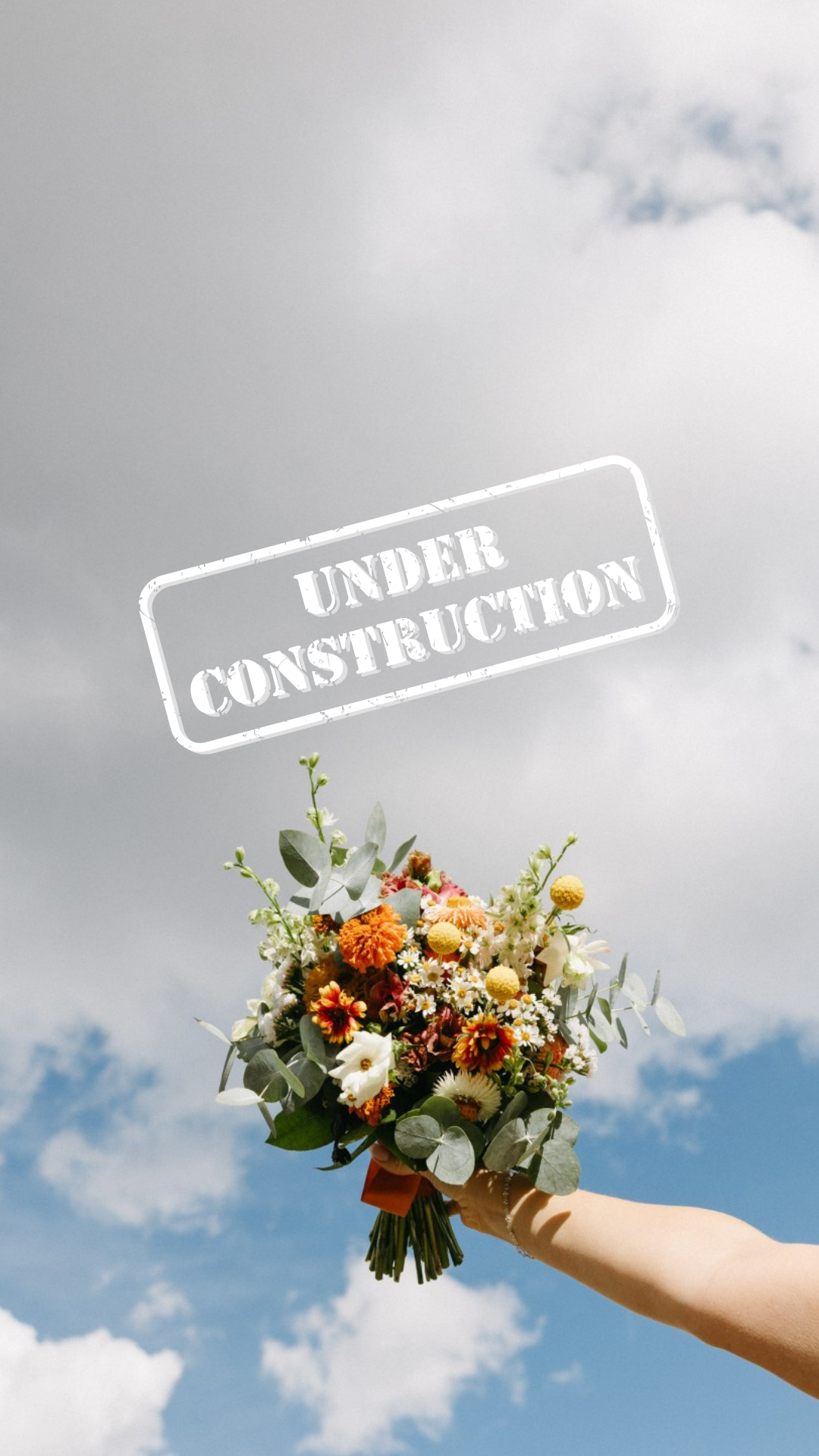 A person holding a colorful bouquet of flowers against a partly cloudy sky with an overlayed stamp that says 'Under Construction'.