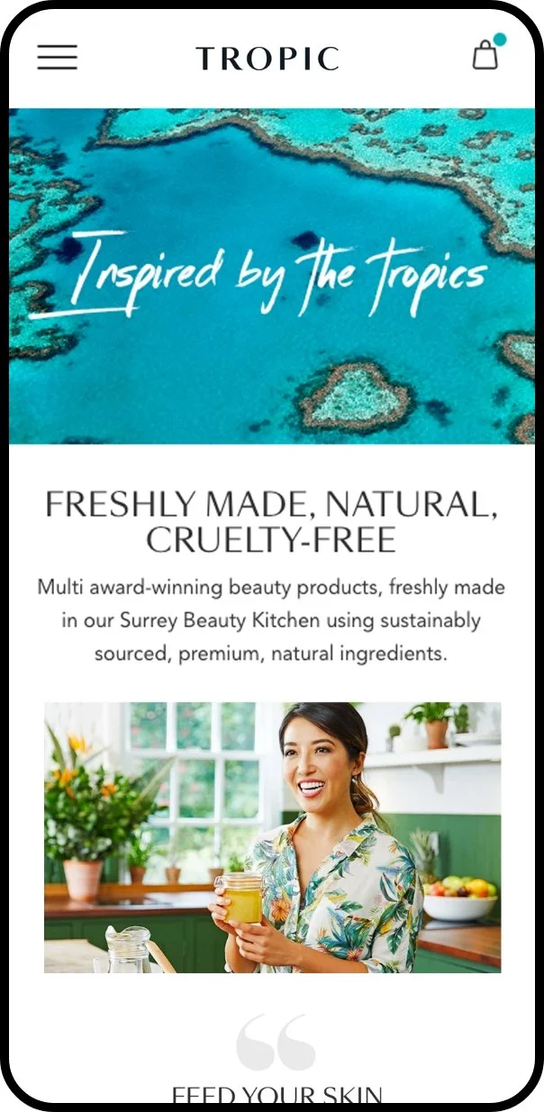 A mobile phone screen displays a website for Tropic beauty products with the slogan "Inspired by the tropics" and a picture of a woman in a bright kitchen holding a jar of product.