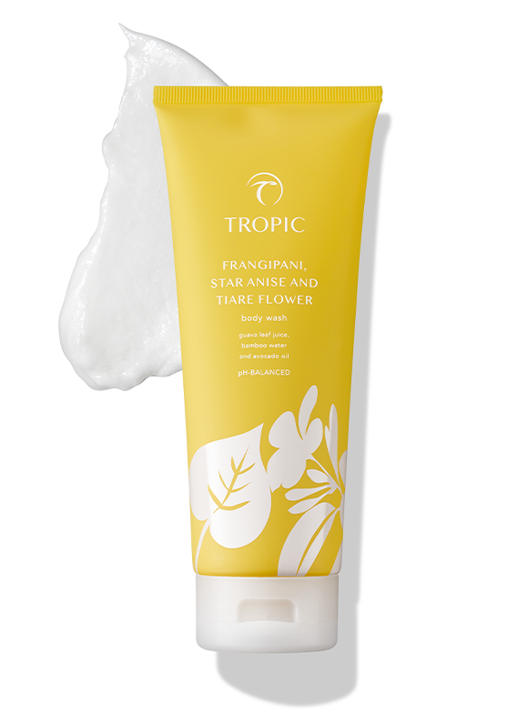 Yellow bottle of Tropic body wash with tropical floral design and a dollop of foam next to it.