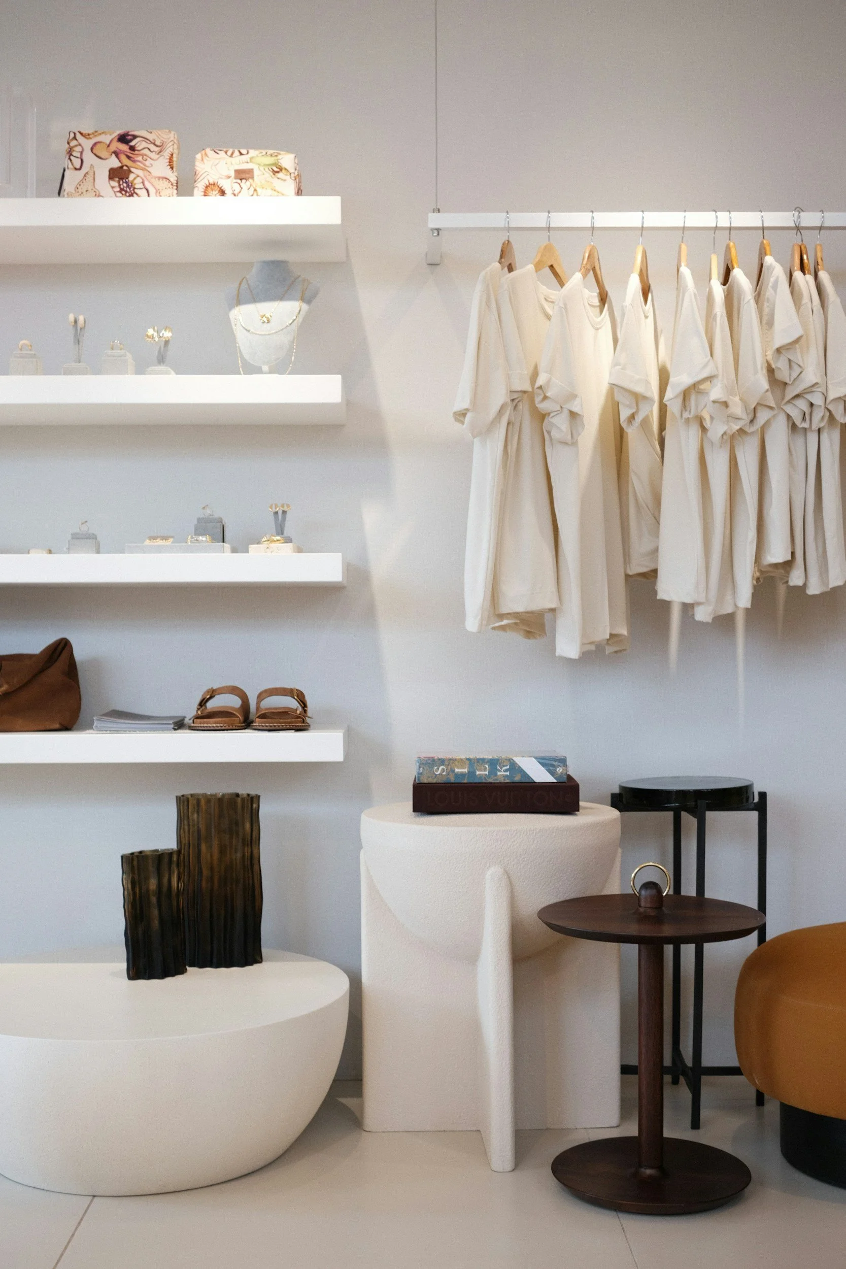 Display of jewelry, handbags, sandals, and clothing inside a boutique store.