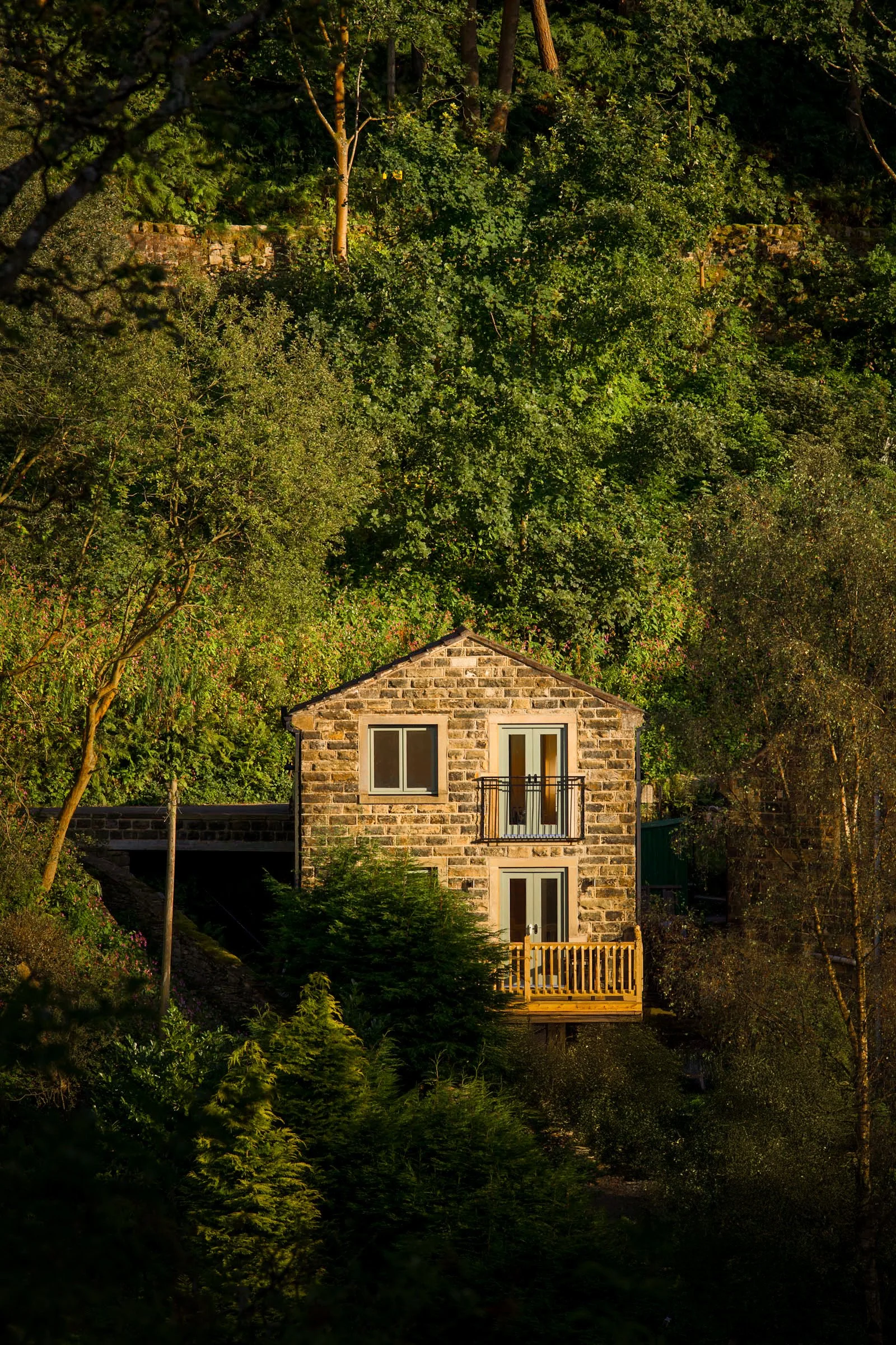 Springwood Studios stone building illuminated at dusk in wooded valley near Hebden Bridge, West Yorkshire