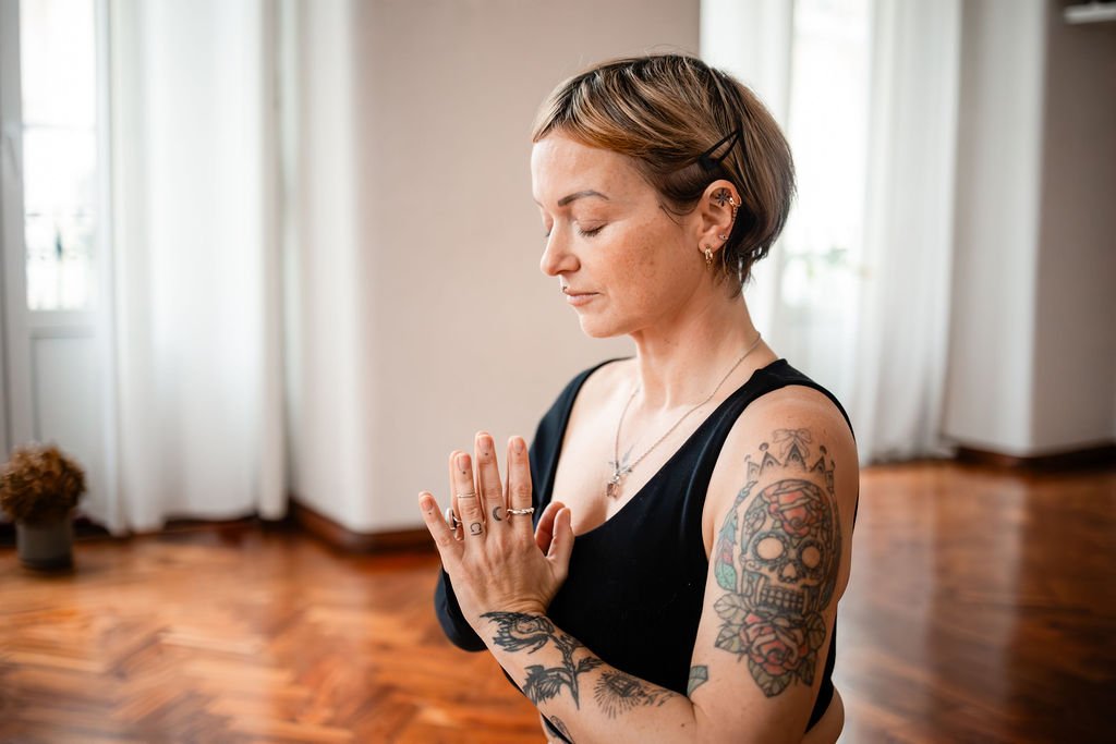 womansitswitheyesclosedhandsinprayerinfrontofherchest