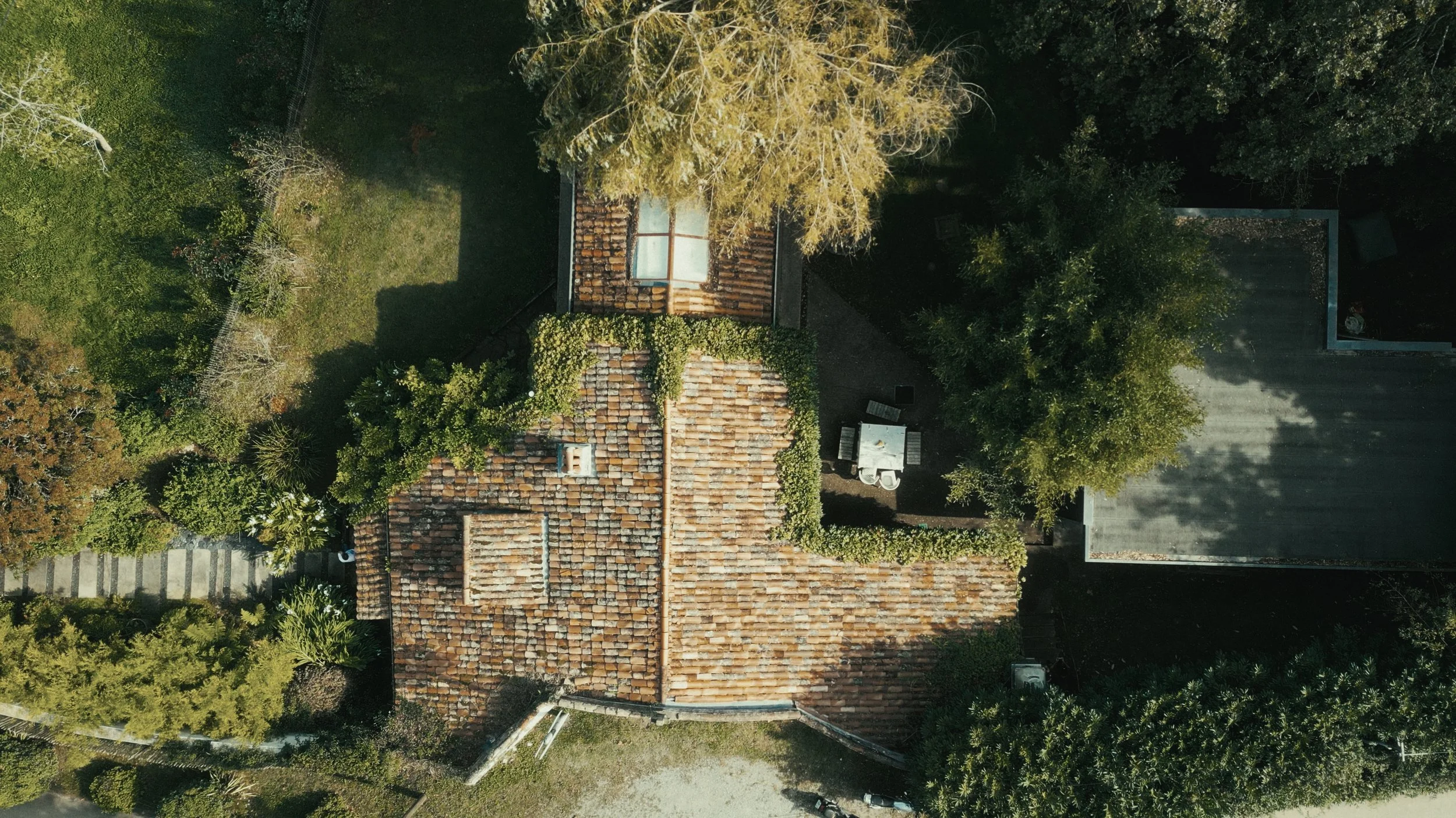 Vue aérienne d'une toiture en tuiles avec des arbres et un espace extérieur