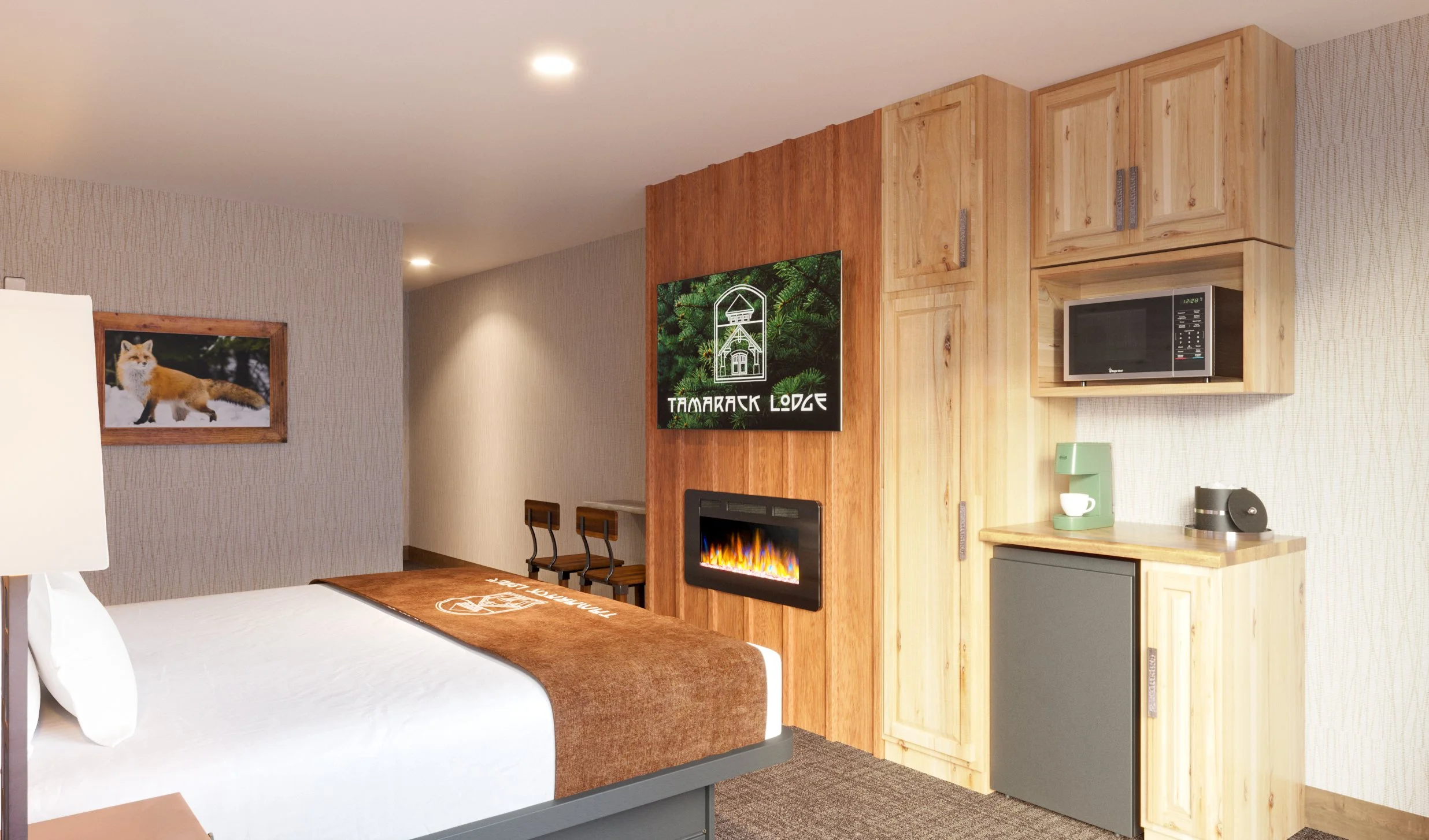 Hotel room with bed, wooden cabinets, a microwave, a mini fridge, a coffee machine, a fireplace, and a television showing the Tamarack Lodge logo