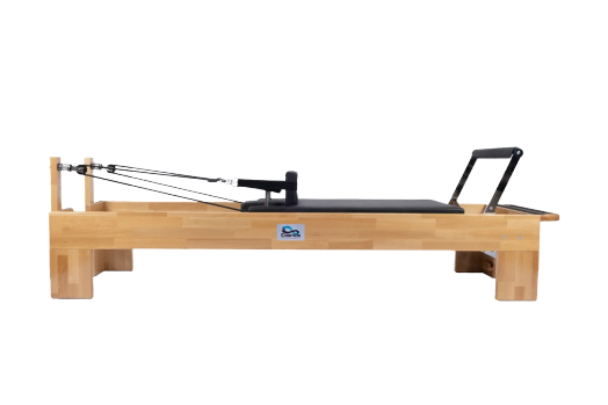 Pilates reformer machine with a wooden frame, black padded carriage, and adjustable straps, placed against a white background.