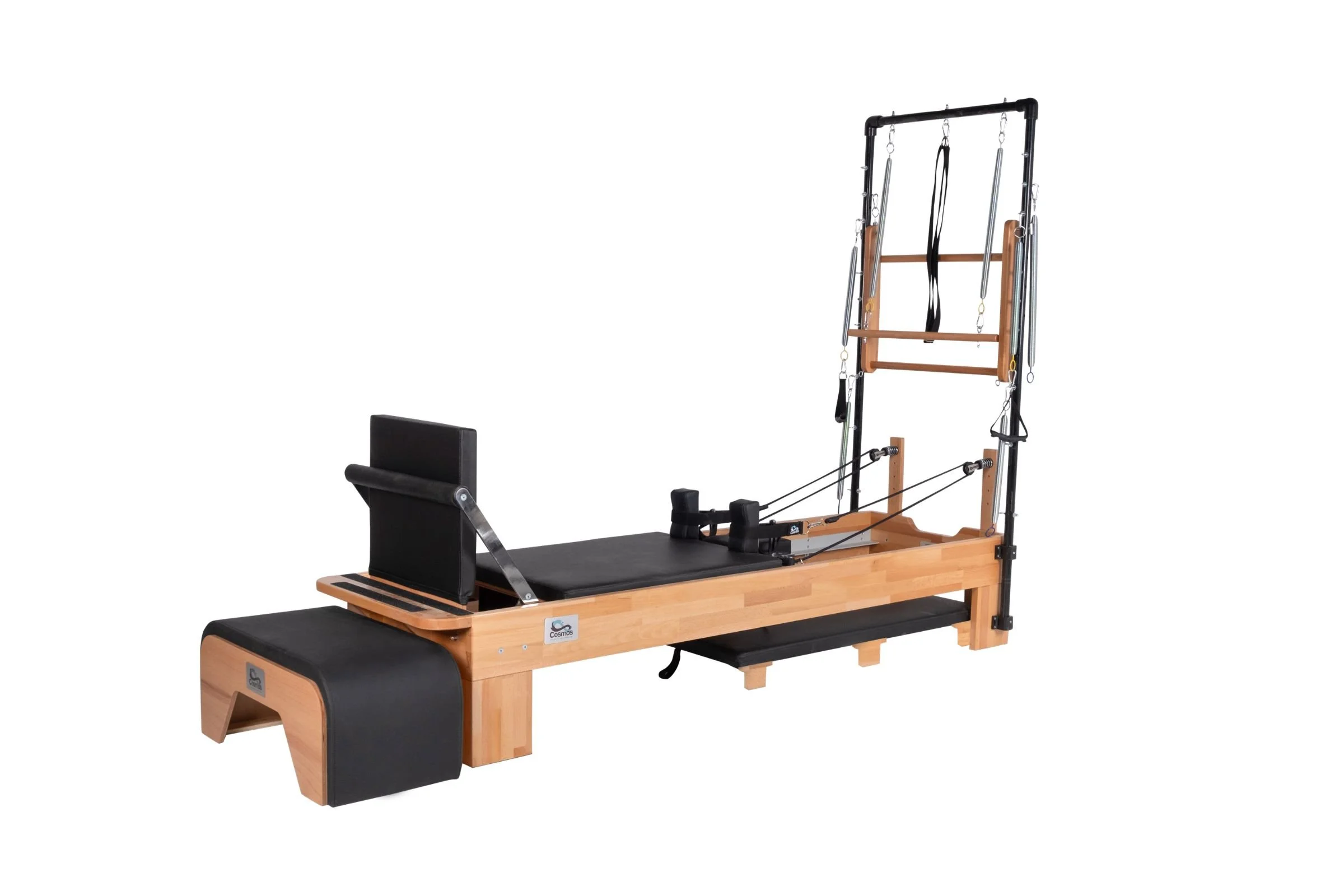 Pilates reformer with wooden frame, black padding, and various attachment straps, against a white background.