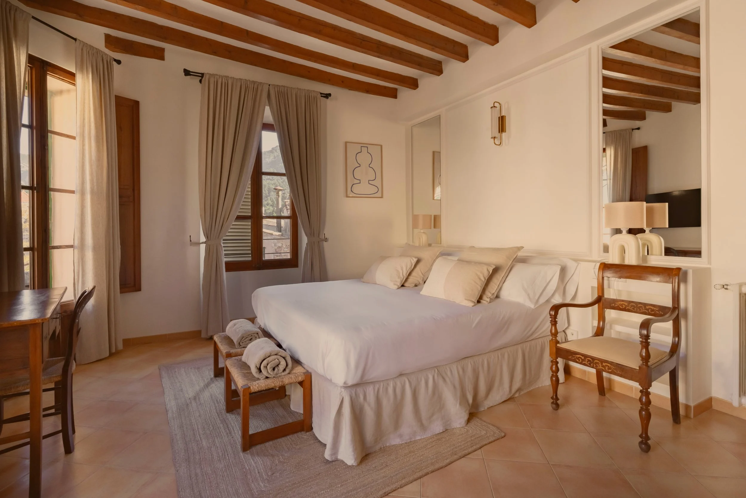 Habitación con cama grande, cortinas beige, ventanas de madera, muebles de madera, y decoración moderna.