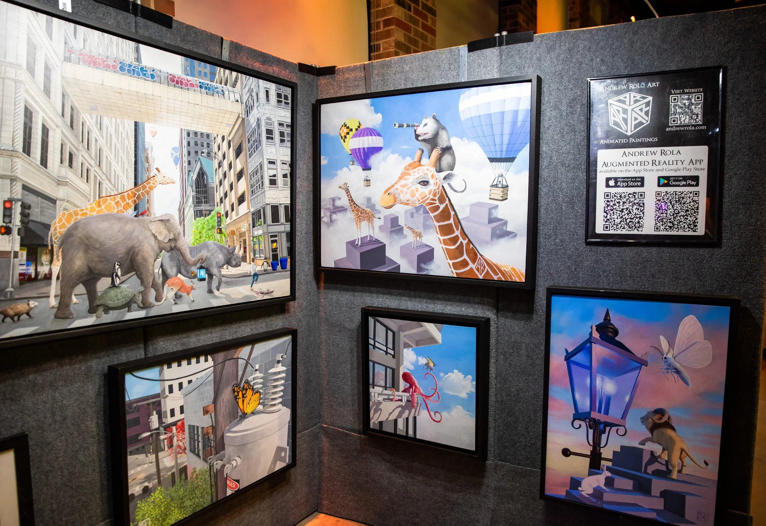 Multiple digital illustrations featuring animals such as giraffes, elephants, a fox, butterflies, and a whale in urban and fantastical settings, displayed on a gallery wall with a QR code and artist information.