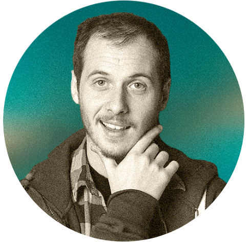 A man with short brown hair and a friendly smile, Ivan Ozegovic, wearing a plaid shirt and a jacket, holding his chin with one hand, posing against a teal background.