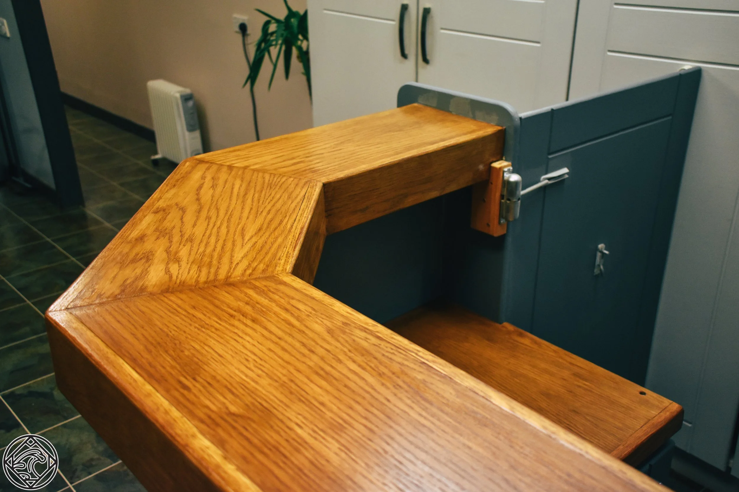 Close-up of a wooden counter or bar with a visible grain pattern, cornered around a blue cabinet or countertop in an indoor setting.