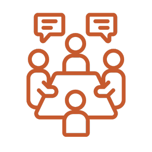 Outline of four people sitting around a table, engaged in a discussion, with two speech bubbles above heads.