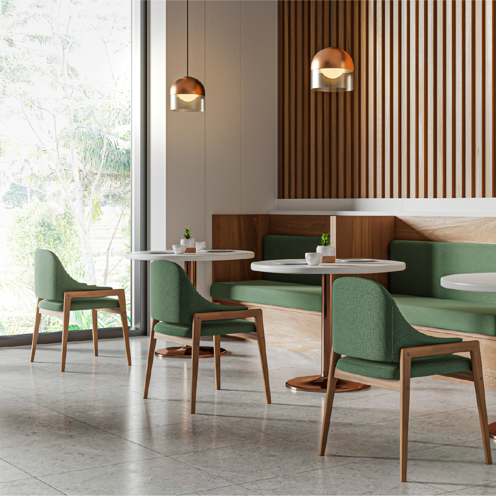 Modern fully custom hotel with green cushioned chairs, white round tables, wooden accents, and hanging copper pendant lights near large window with view of trees.