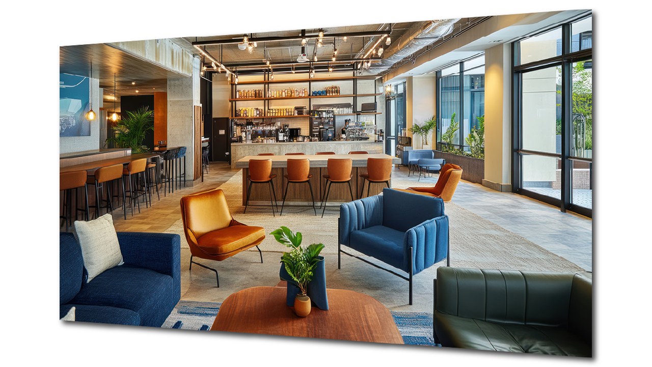 Modern custom hotel lobby with colorful seating including blue, green, and orange chairs, a bar area with stools, large windows letting in natural light, and a cozy, stylish atmosphere.