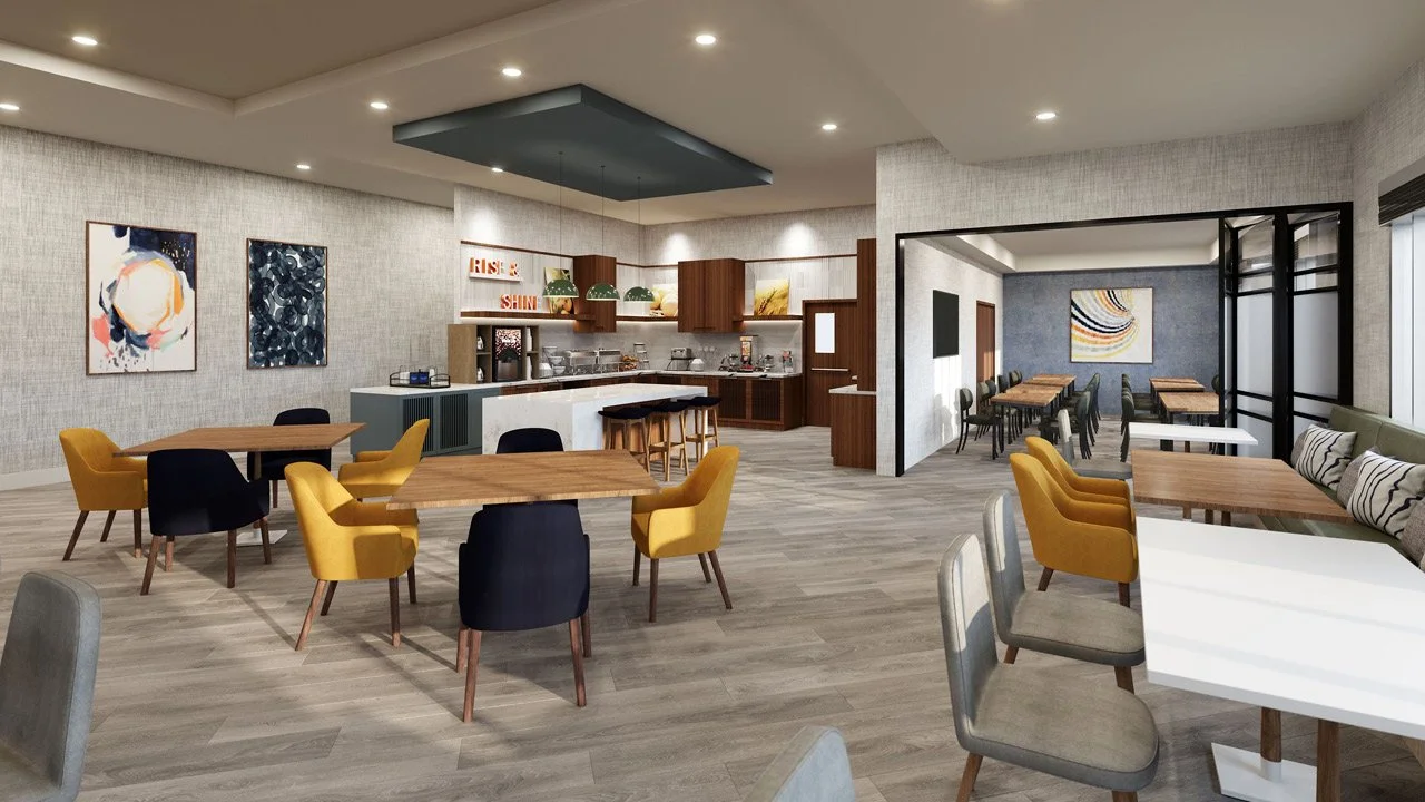 A modern Comfort by Choice Rise & Shine dining and breakfast area with multiple tables and chairs, a small breakfast bar, artwork on the walls, and a breakfast bar with kitchen appliances in the background.