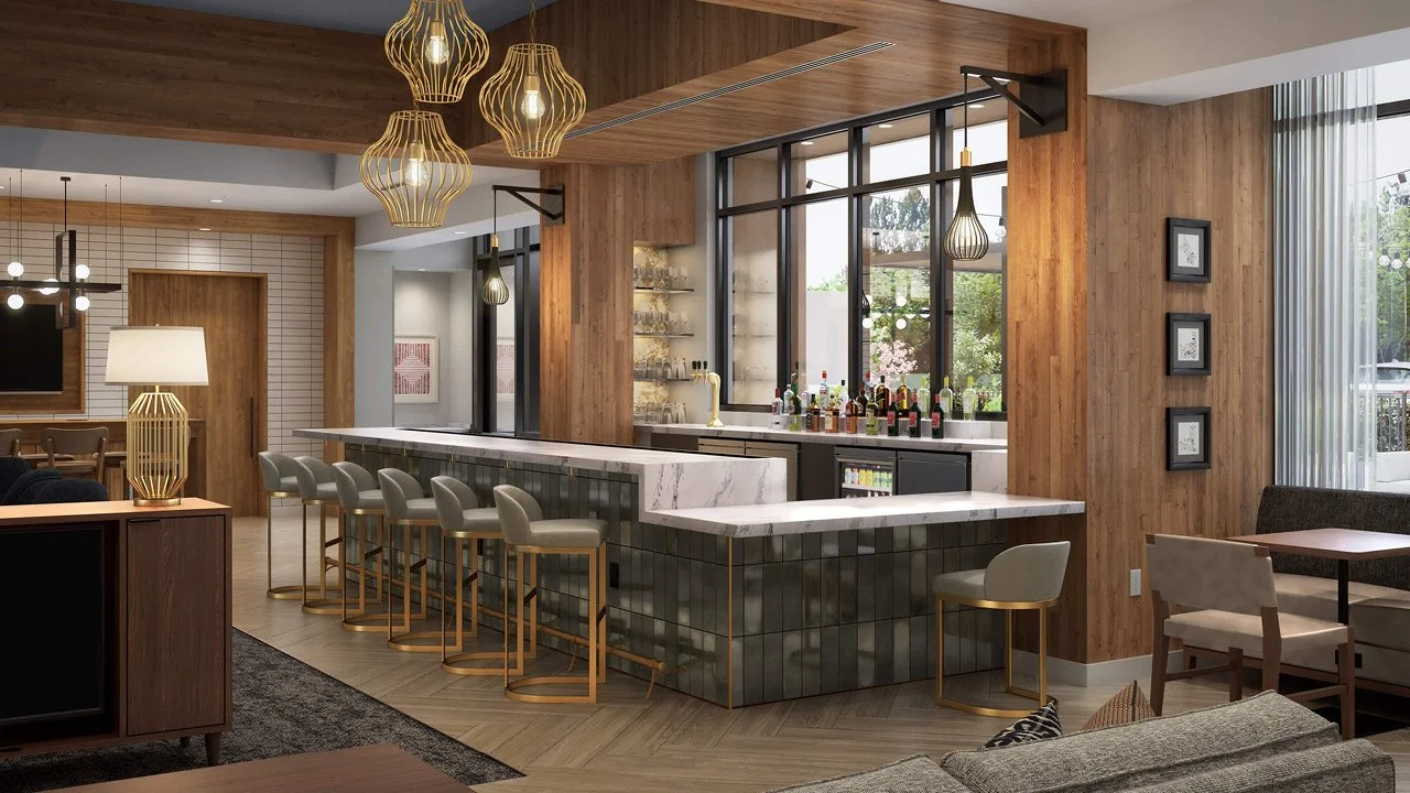 Interior of a modern prototype Staybridge by IHG hotel bar with a marble countertop, bar stools, decorative pendant lights, a wooden wall with picture frames, a cozy sitting area, and a large window with curtains.