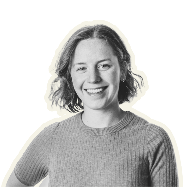 A black and white portrait of a smiling young woman with short, wavy hair, wearing a ribbed sweater.