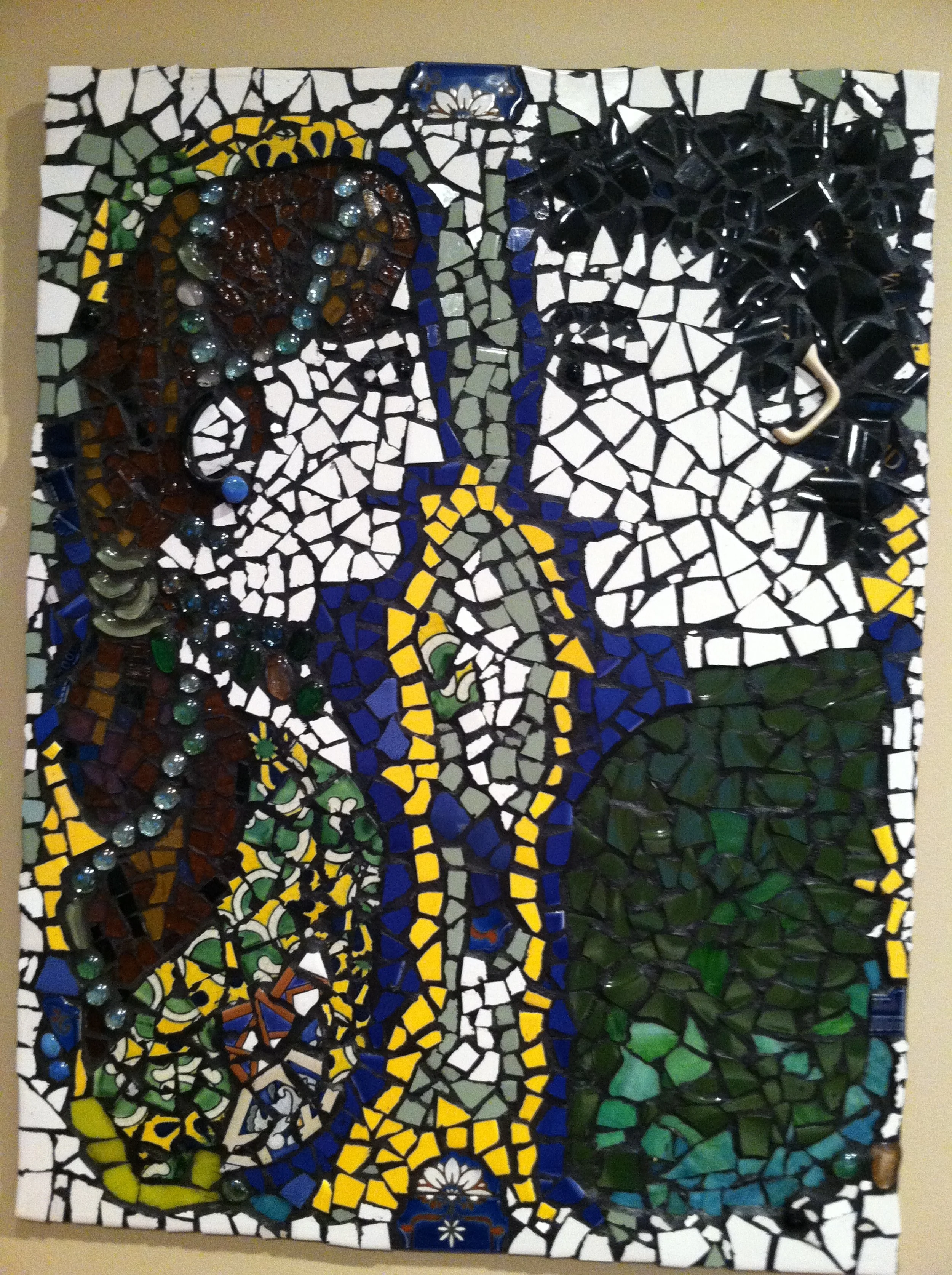 Colorful mosaic artwork featuring a woman with brown hair and a black top, a large white flower, a blue bottle of beer, and a green landscape background.