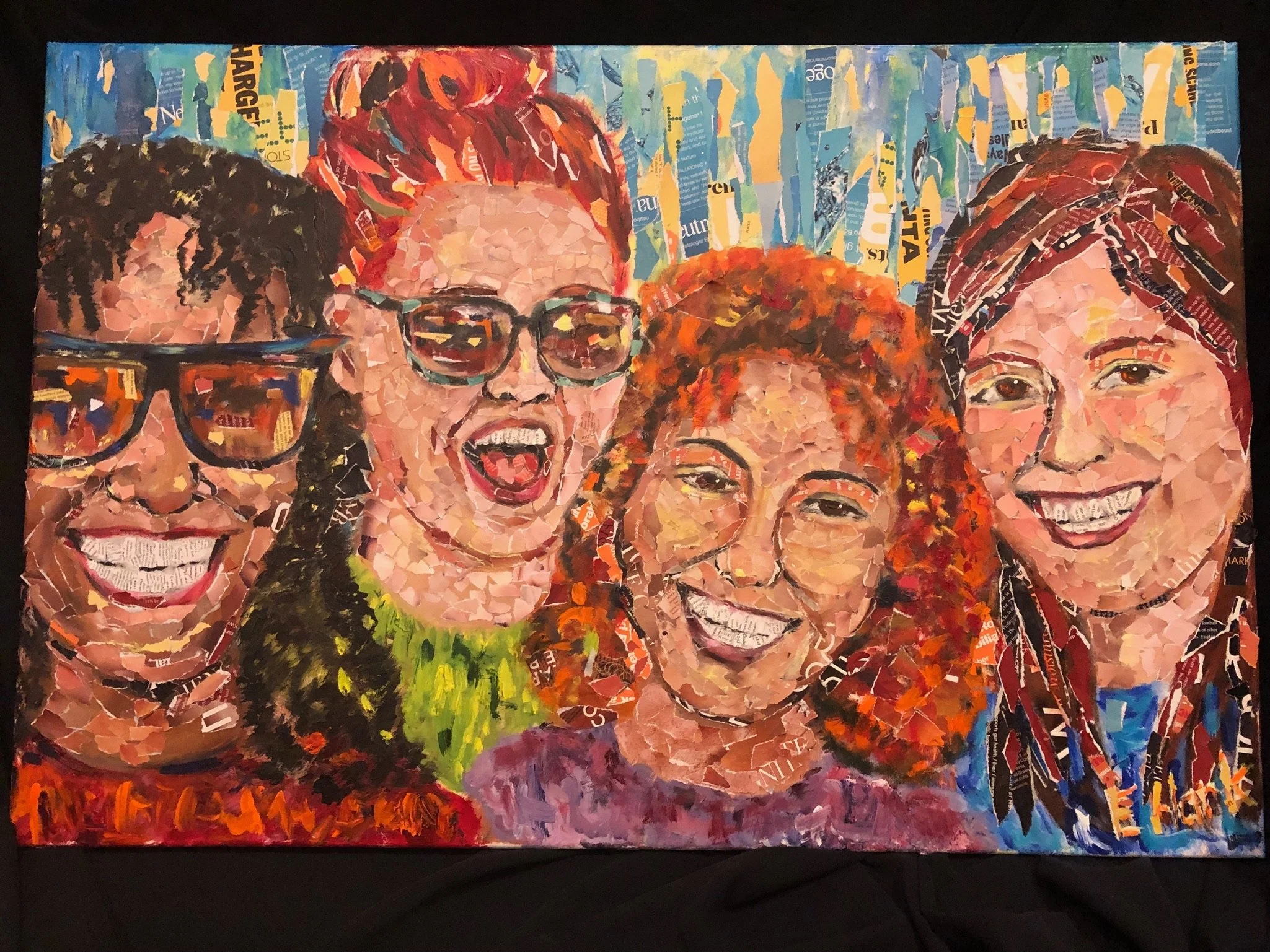 Colorful mosaic portrait of four women with different hairstyles and glasses, smiling and showing teeth, made from torn paper pieces.
