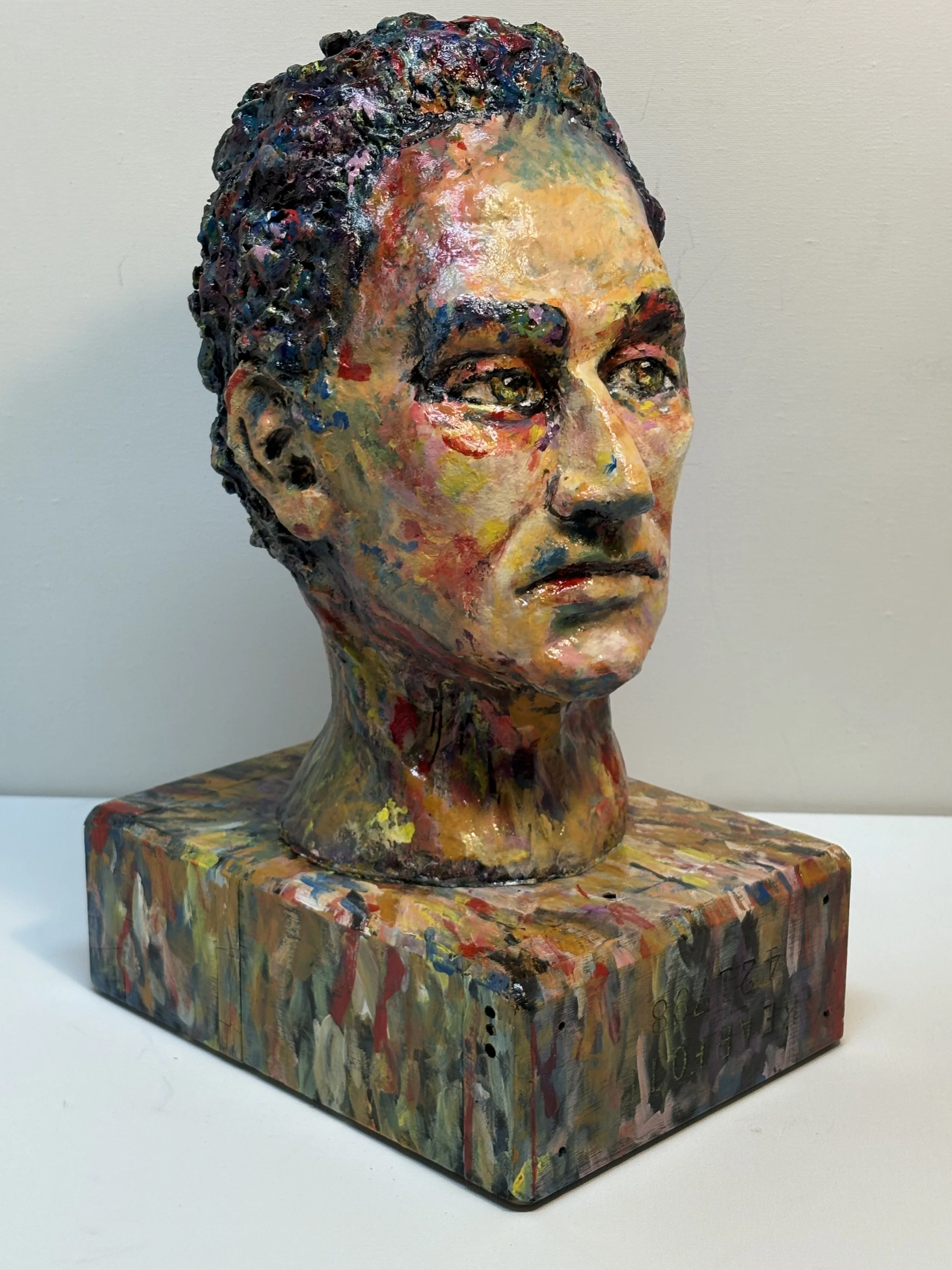 Painted sculpture of a woman’s head and shoulders with a colorful, abstract style, mounted on a matching painted base.