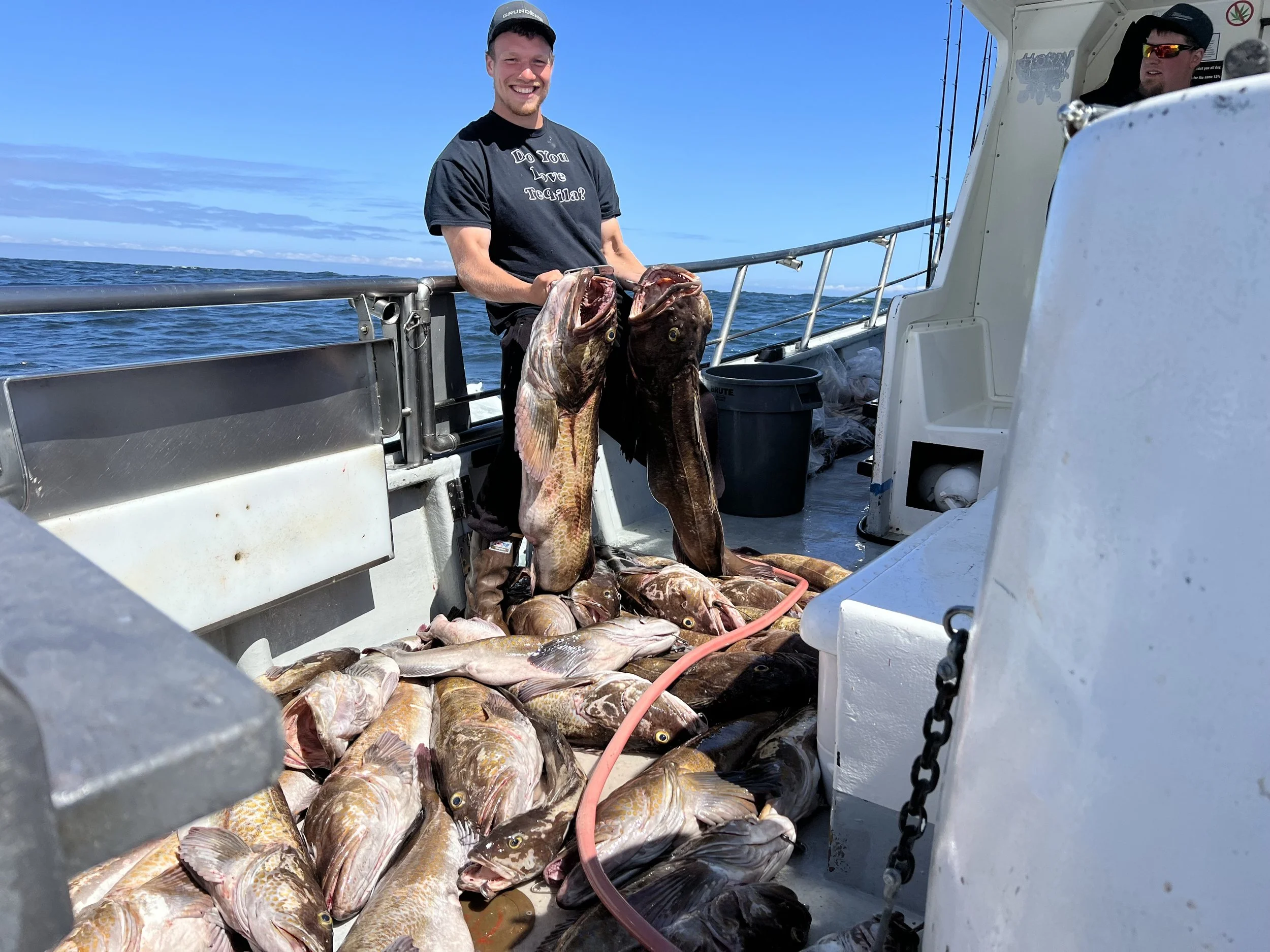 Our deckhand for the tequila too, holding a large lingcod with a bunch of large lingcod on deep water fishing charter