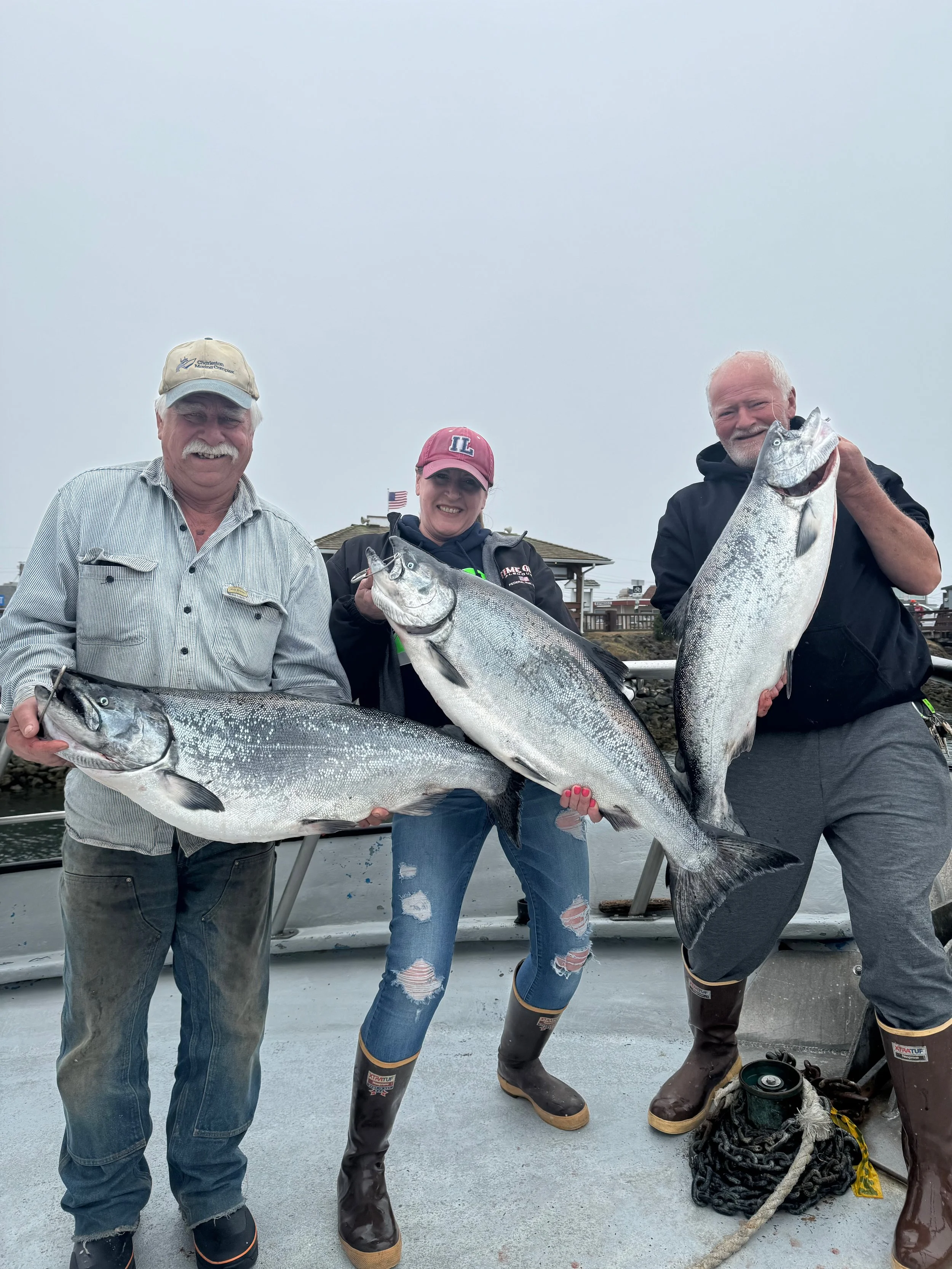 3 customers holding 3 nice silver chinook salmon on deck of the tequila too on an ocean Sportfishing charter