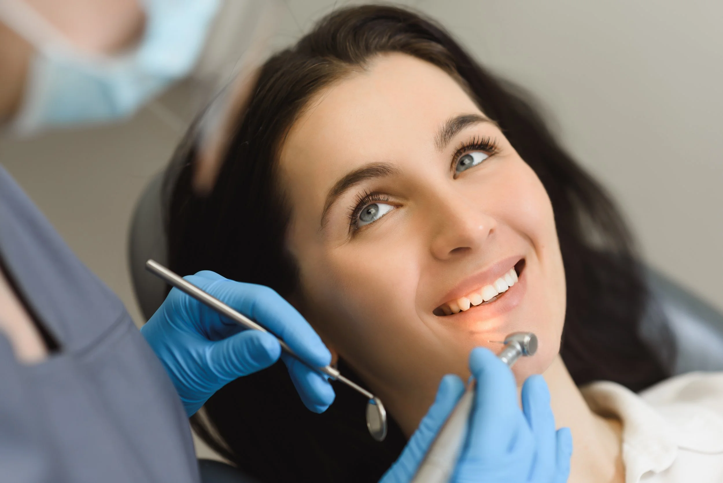 A woman at the dentist smiling during a dental check-up.