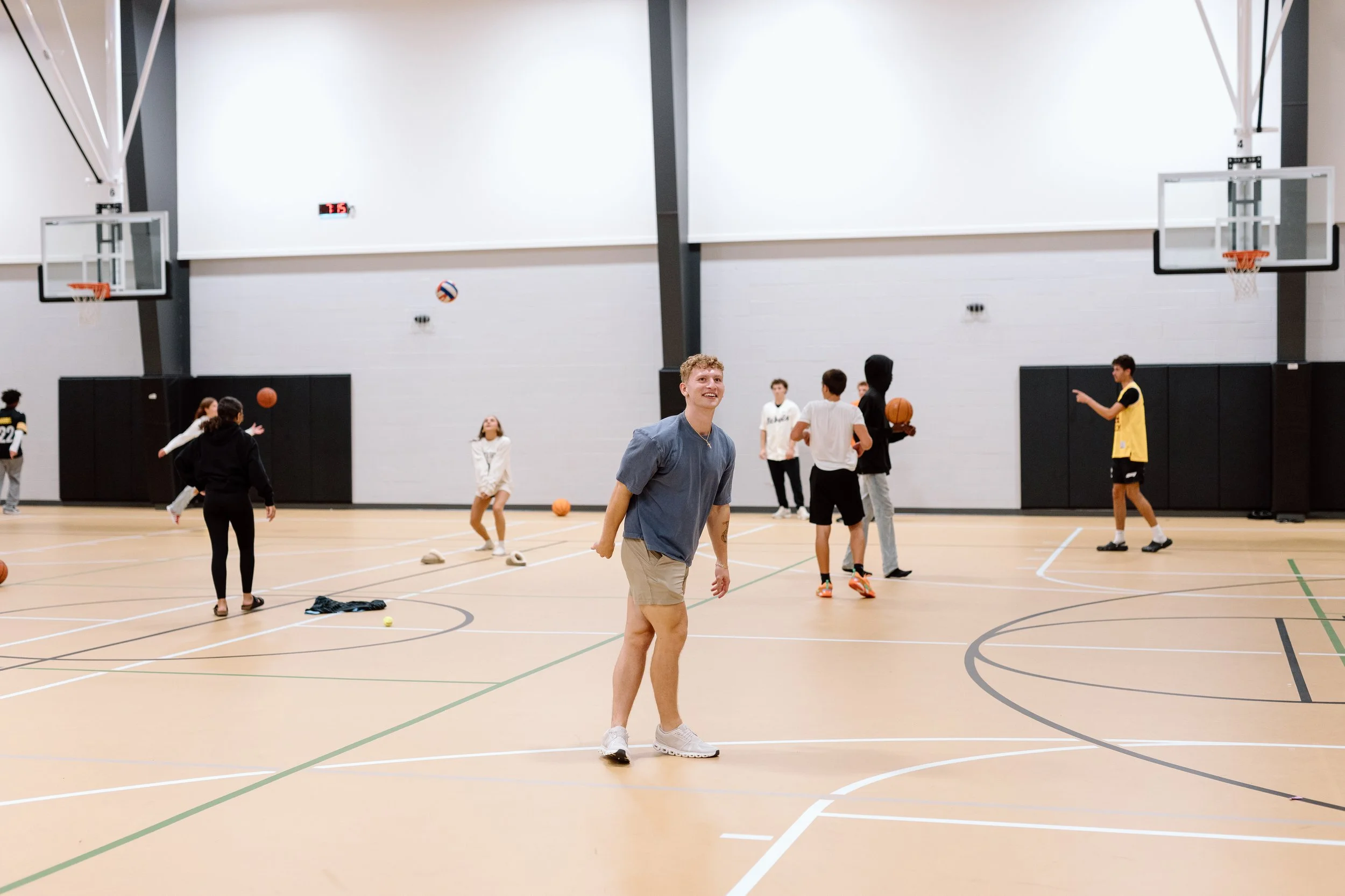 Young people playing basketball and practicing on an indoor court