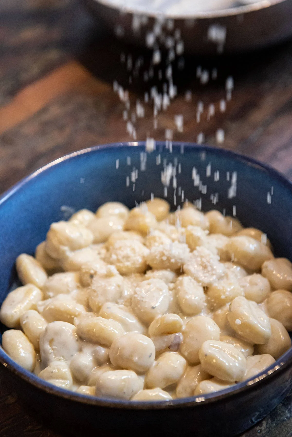 Gnocchi pere e gorgonzola, vengono spolverati con Parmigiano Reggiano grattugiato.
