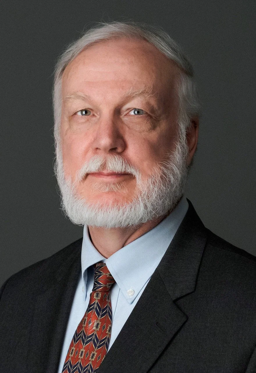 A smiling man in a dark blazer