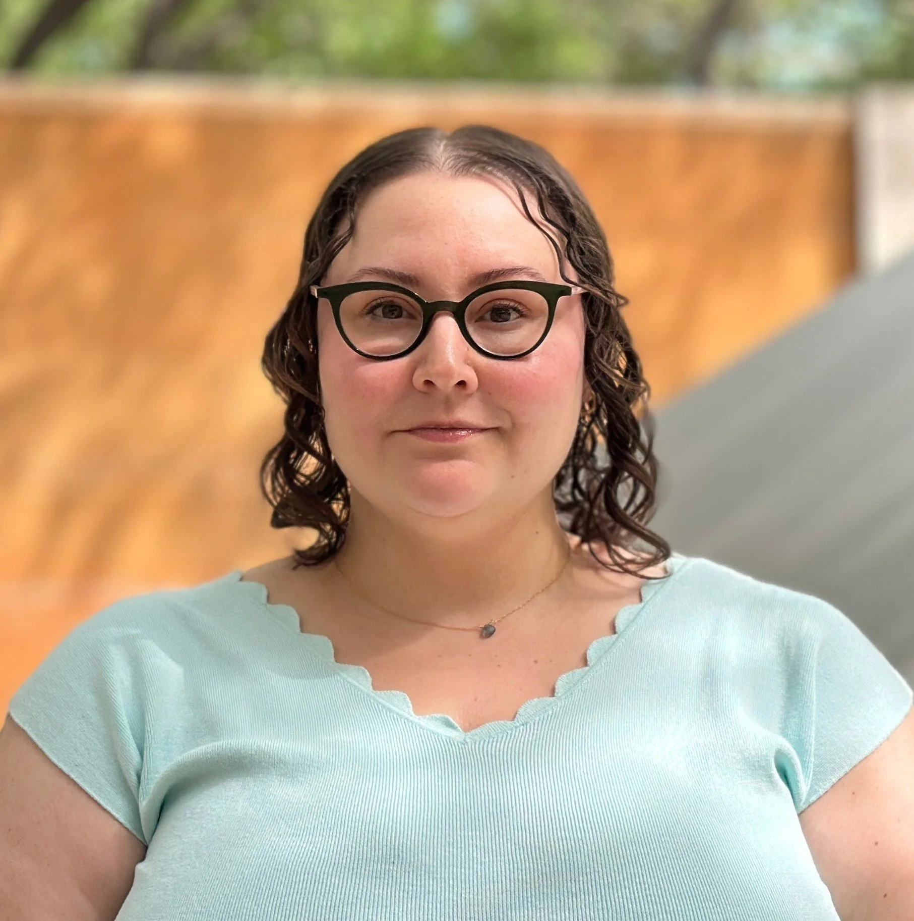 A smiling woman in a light blue top
