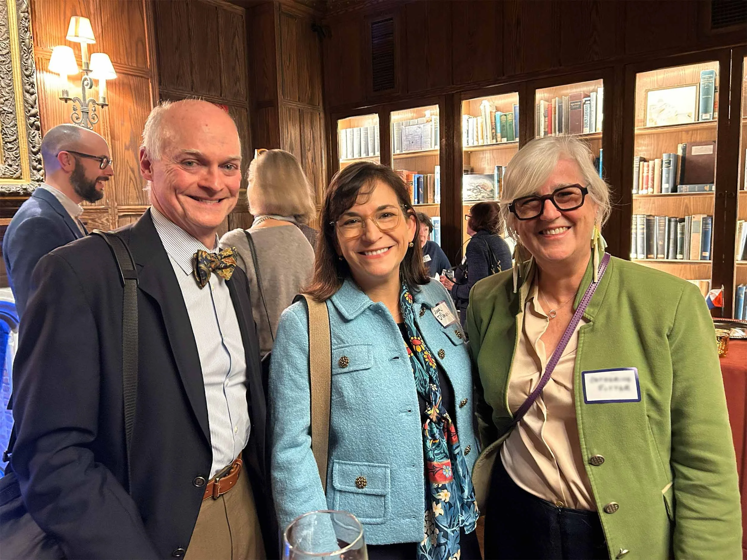 Three people smile for the camera at a gathering