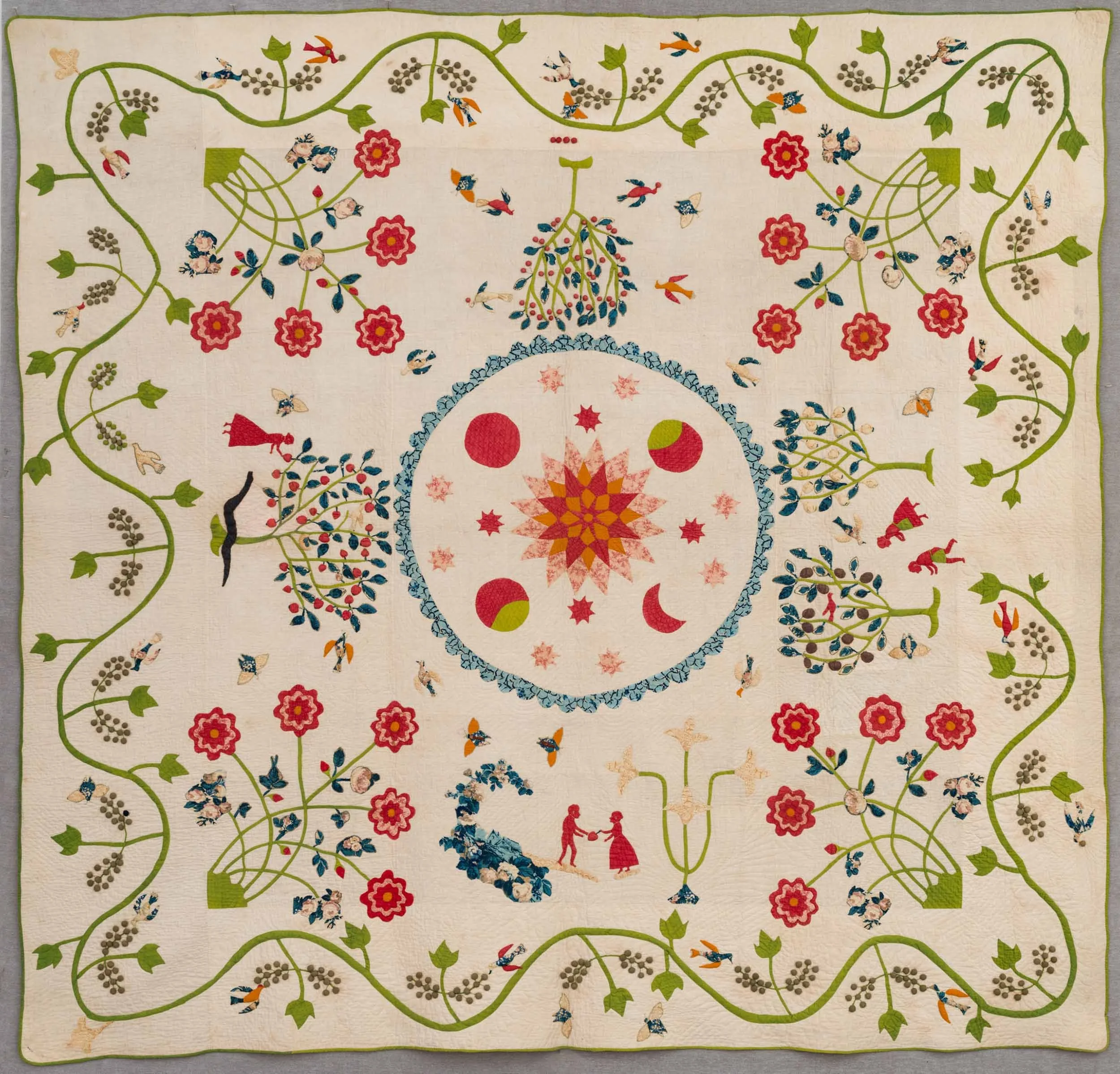 Detail of a quilt with a sun, moon, and floral pattern