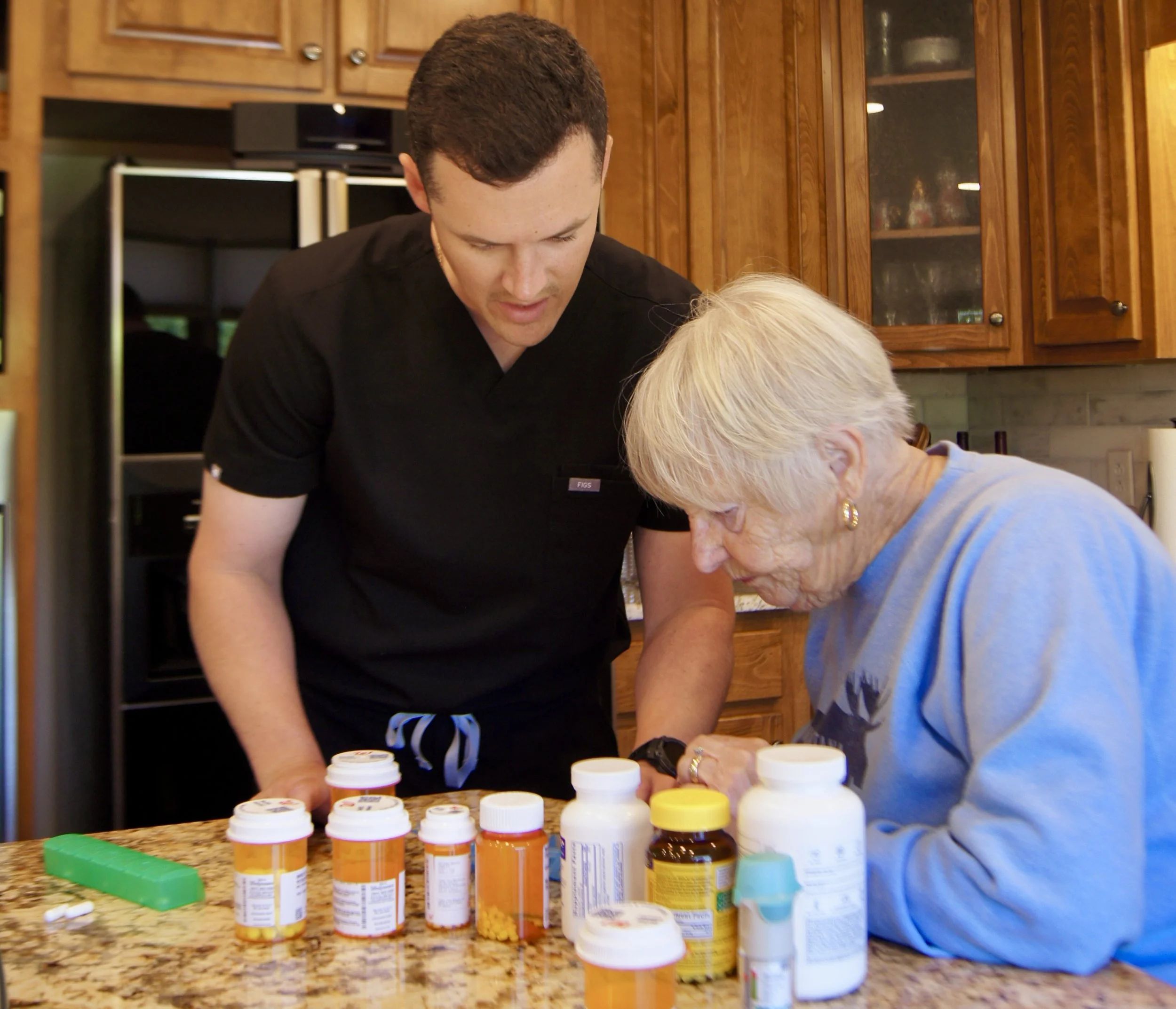 Gus Osgood RN reviewing prescription medications with an elderly client at her home as part of ongoing concierge nursing oversight in Nashville Tennessee
