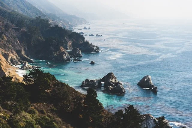 Coastal cliffs with rocky shoreline and turquoise water, view from above