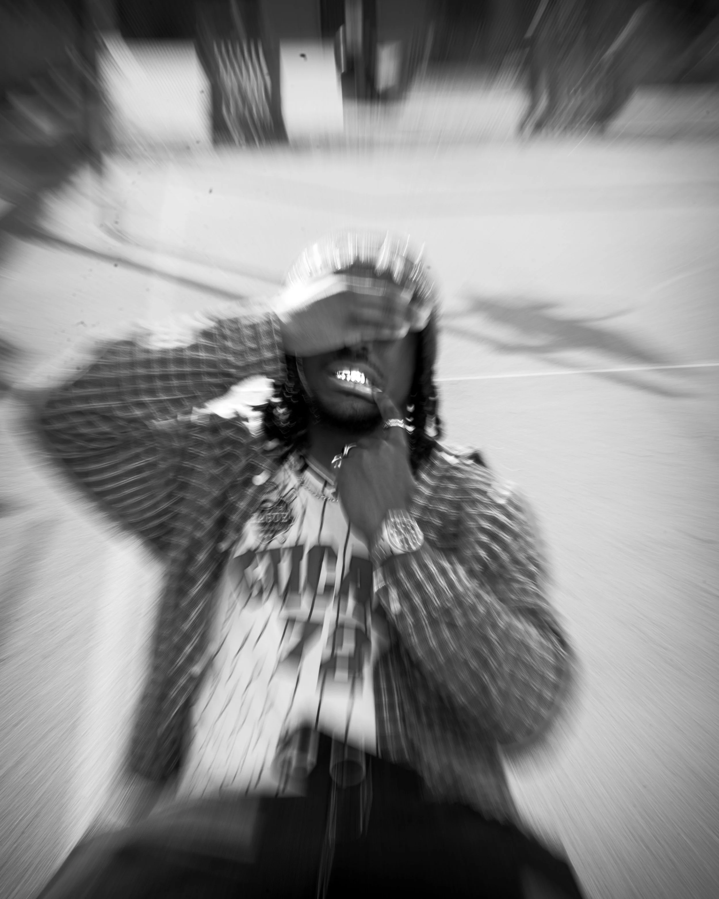 Une personne semble faire du skate dans une position dynamique, avec un arrière-plan flou en raison du mouvement rapide.