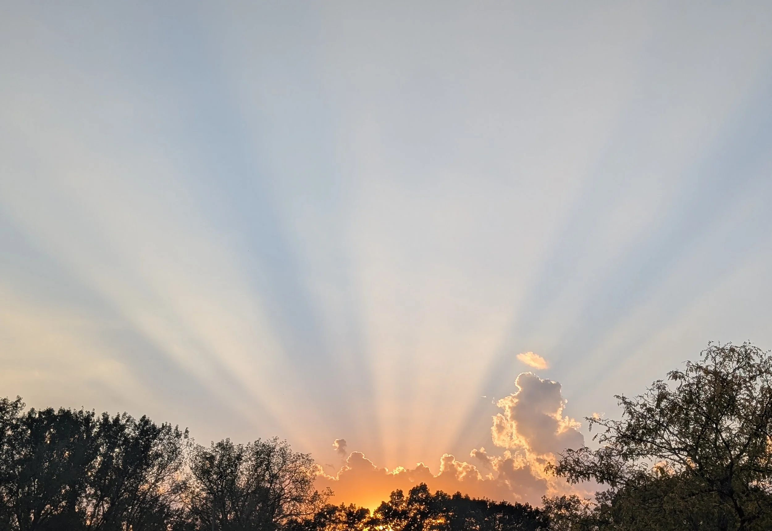 Minnesota at sunset with what look to me like rays of hope and a reminder of our connection to something bigger, whether that's Earth, the universe, or a named higher power.