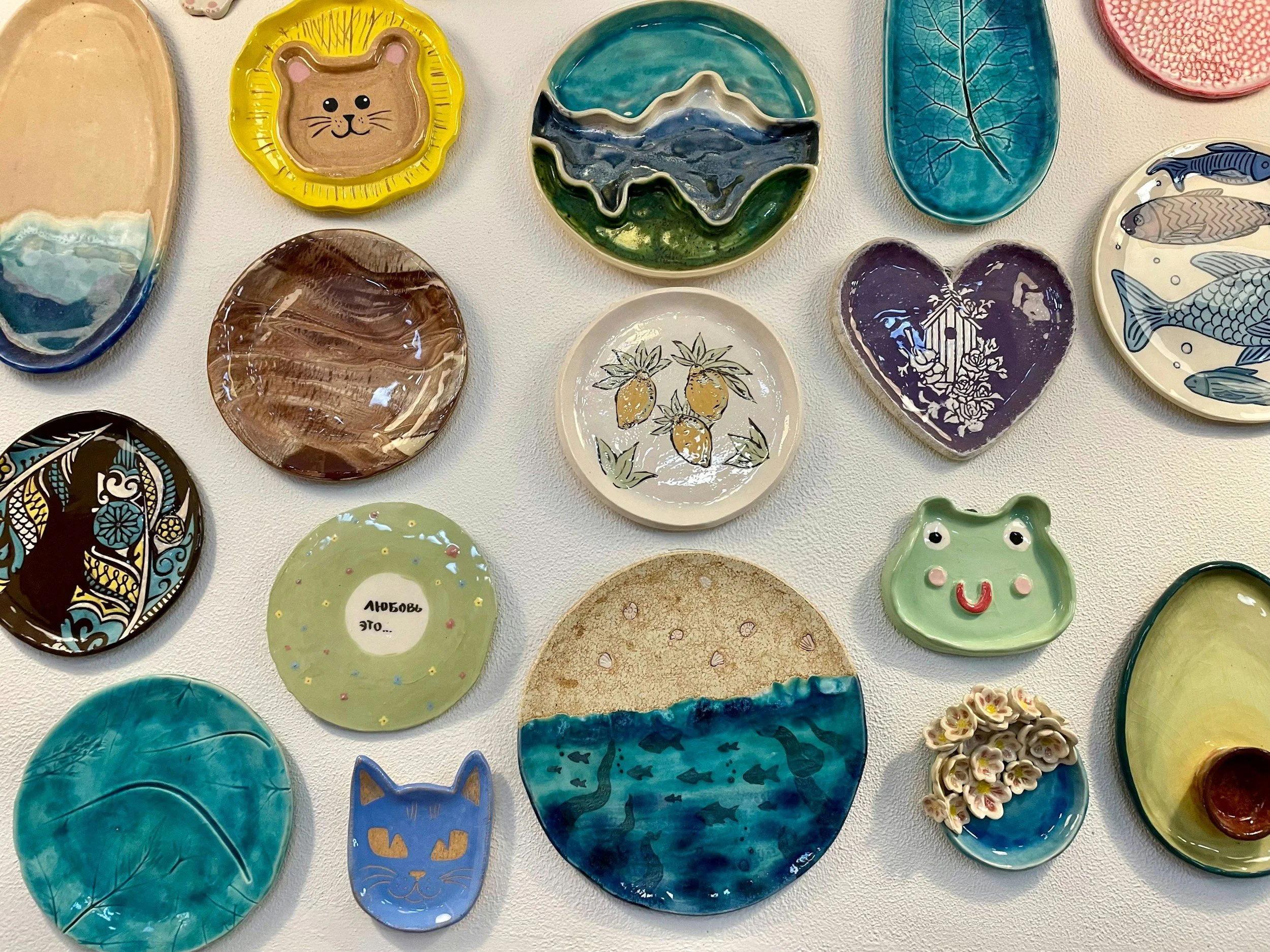 Flatlay of colorful plates decorated with different underglaze techniques.