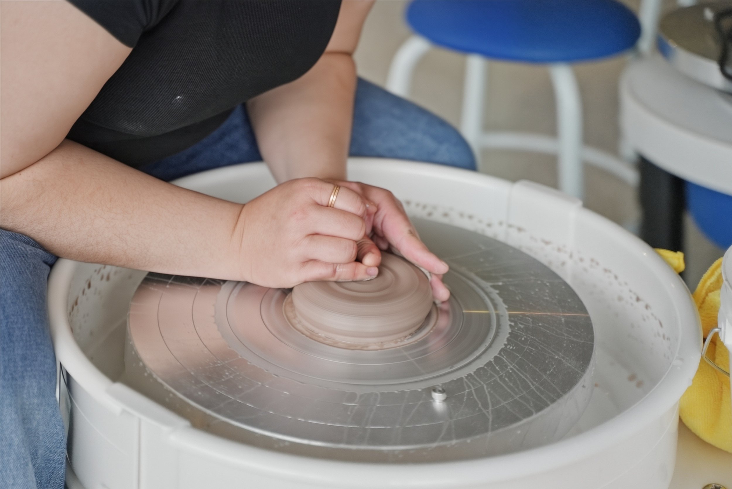 Person on the pottery wheel throwing clay
