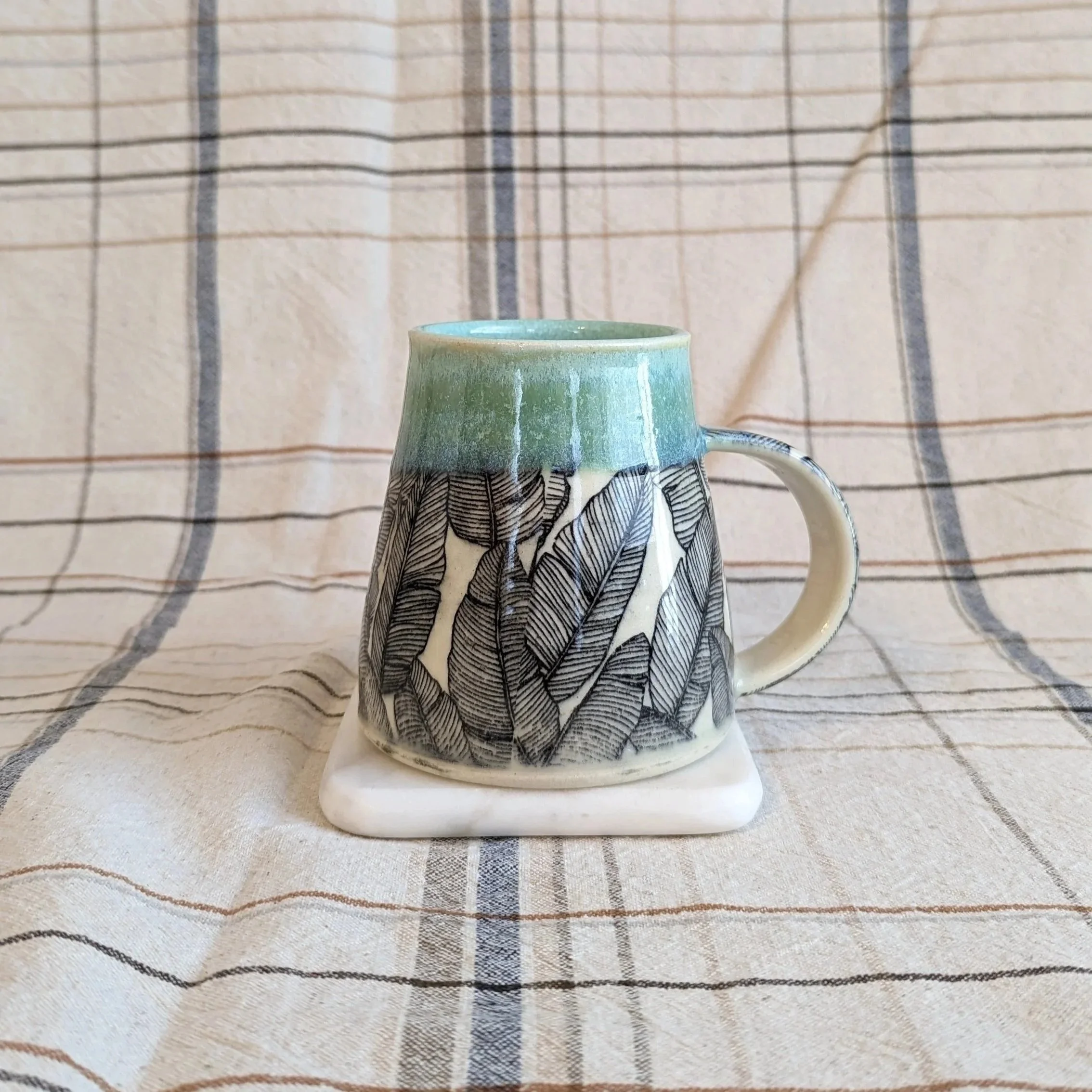 Green pottery mug with leaf decal