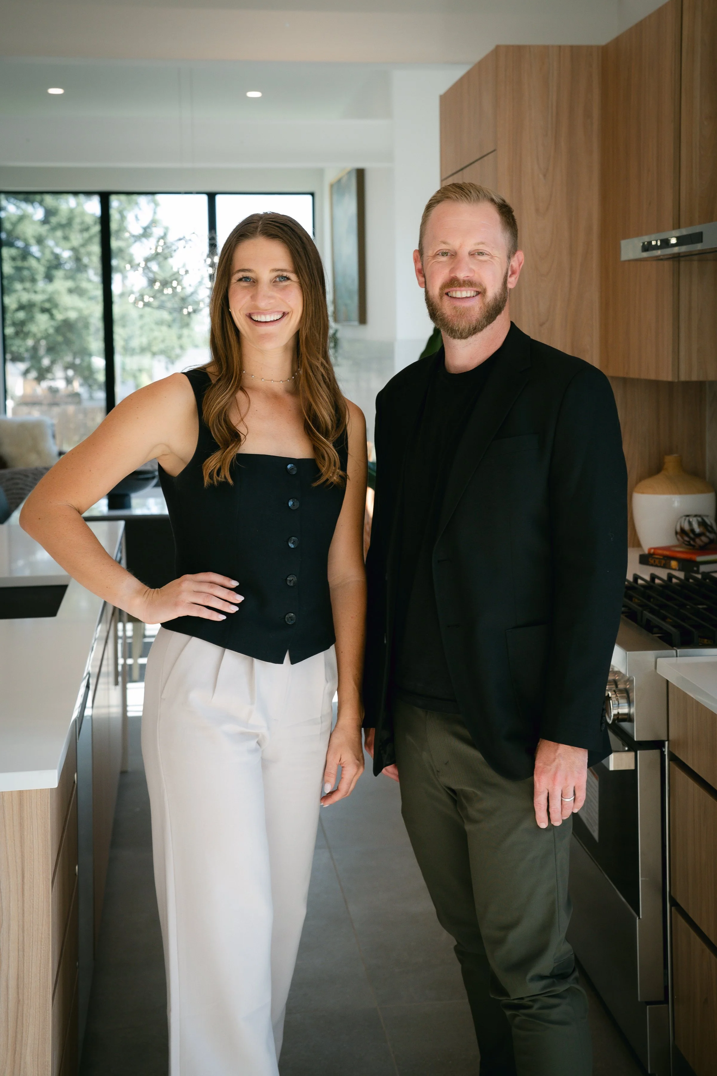 Co-founders of The Eminence Group, Denver real estate advisors, standing in a modern home
