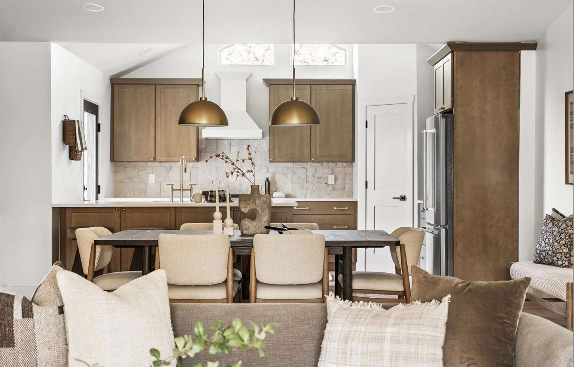 Open-concept kitchen and dining area in a Denver home with wood cabinetry, modern lighting, and natural finishes.