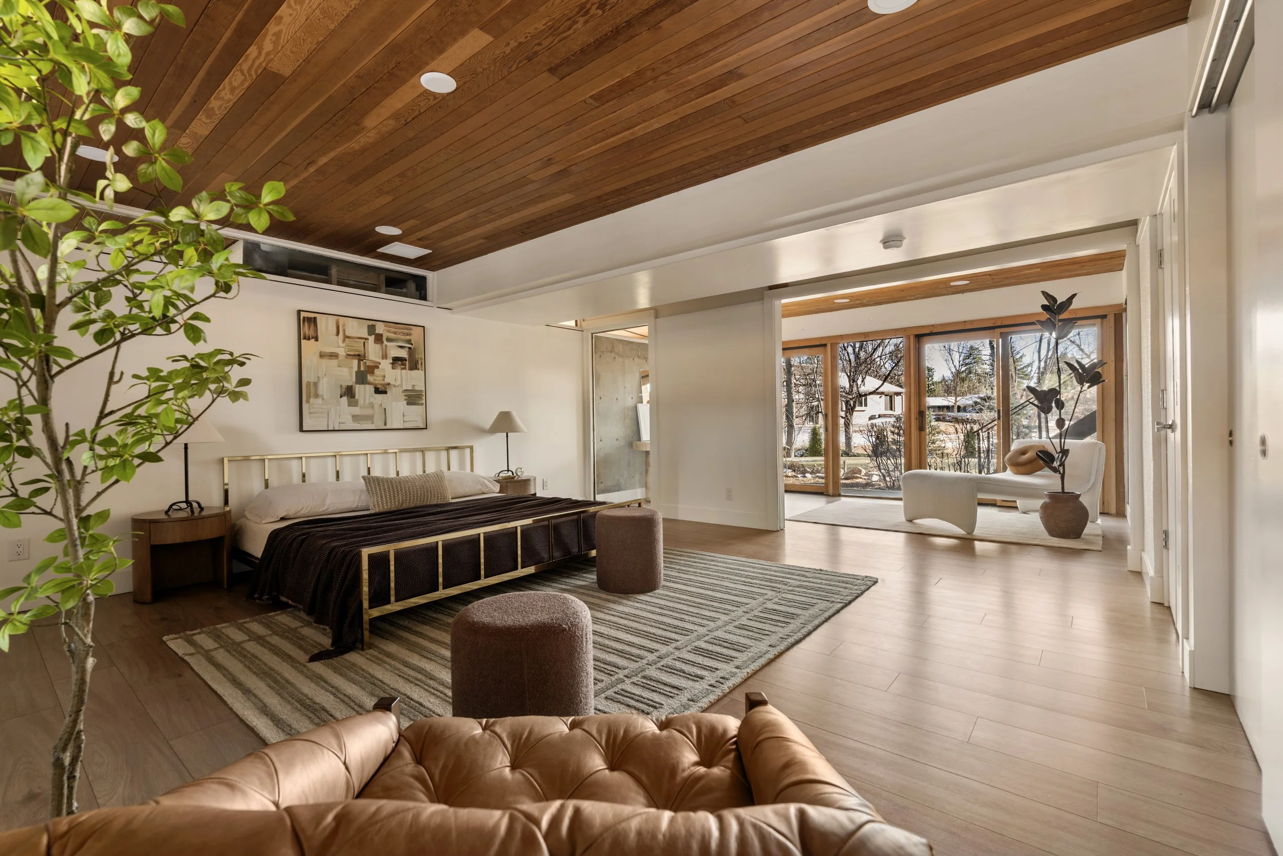 Spacious Denver primary bedroom suite with wood ceiling, large windows, and open layout
