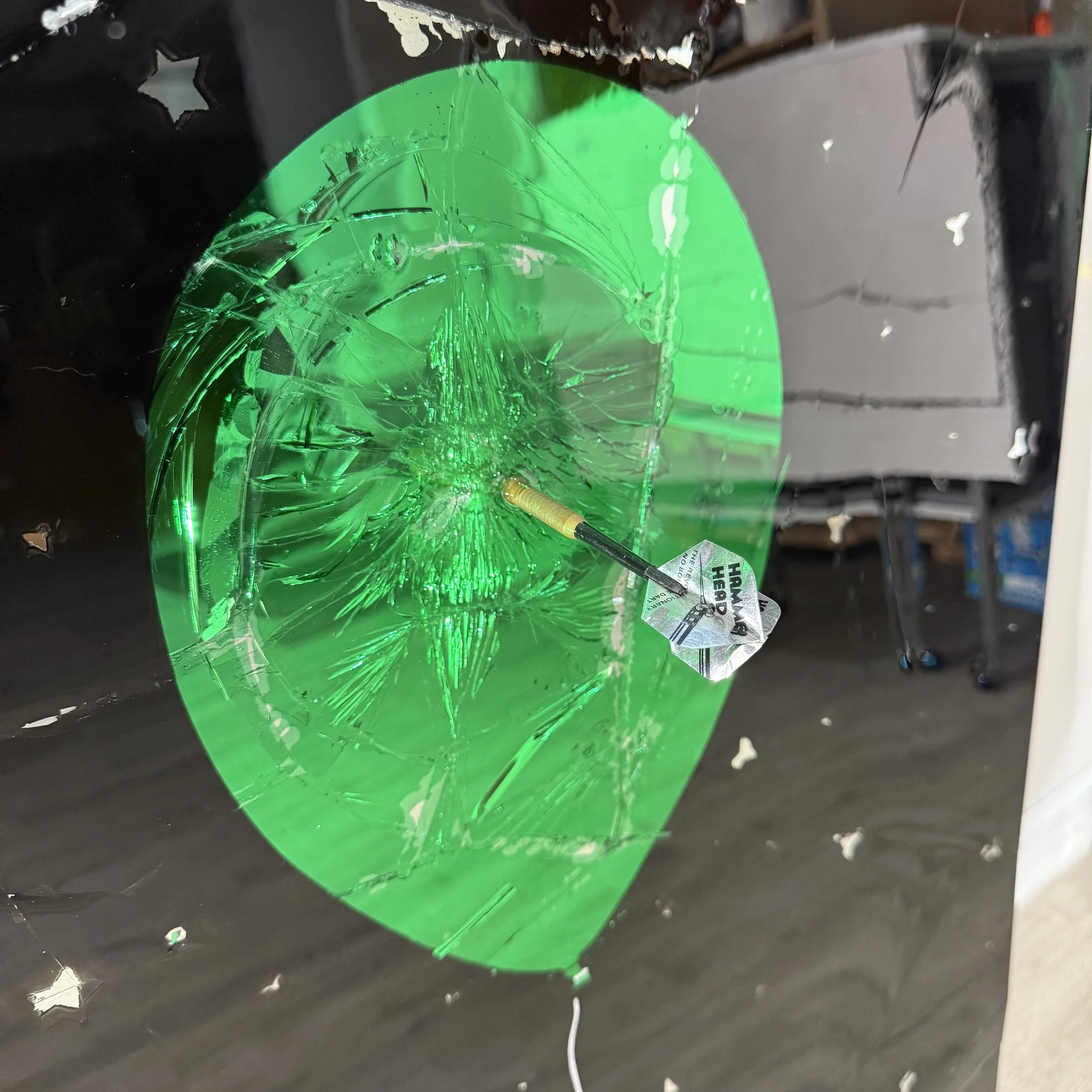 Stained glass paint, spray paint, acrylic, epoxy resin and a real playing dart on intentionally-shattered mirror. Mounted to canvas. 24 x 36 in.