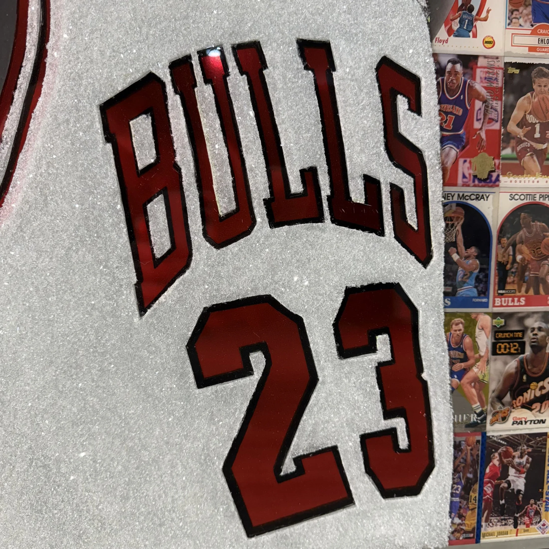 Graphite portrait layered over original NBA trading cards from Michael Jordan's active years. Stained glass paint, ink, resin and diamond dust on mirror. Mounted to canvas. 24 x 36 in.