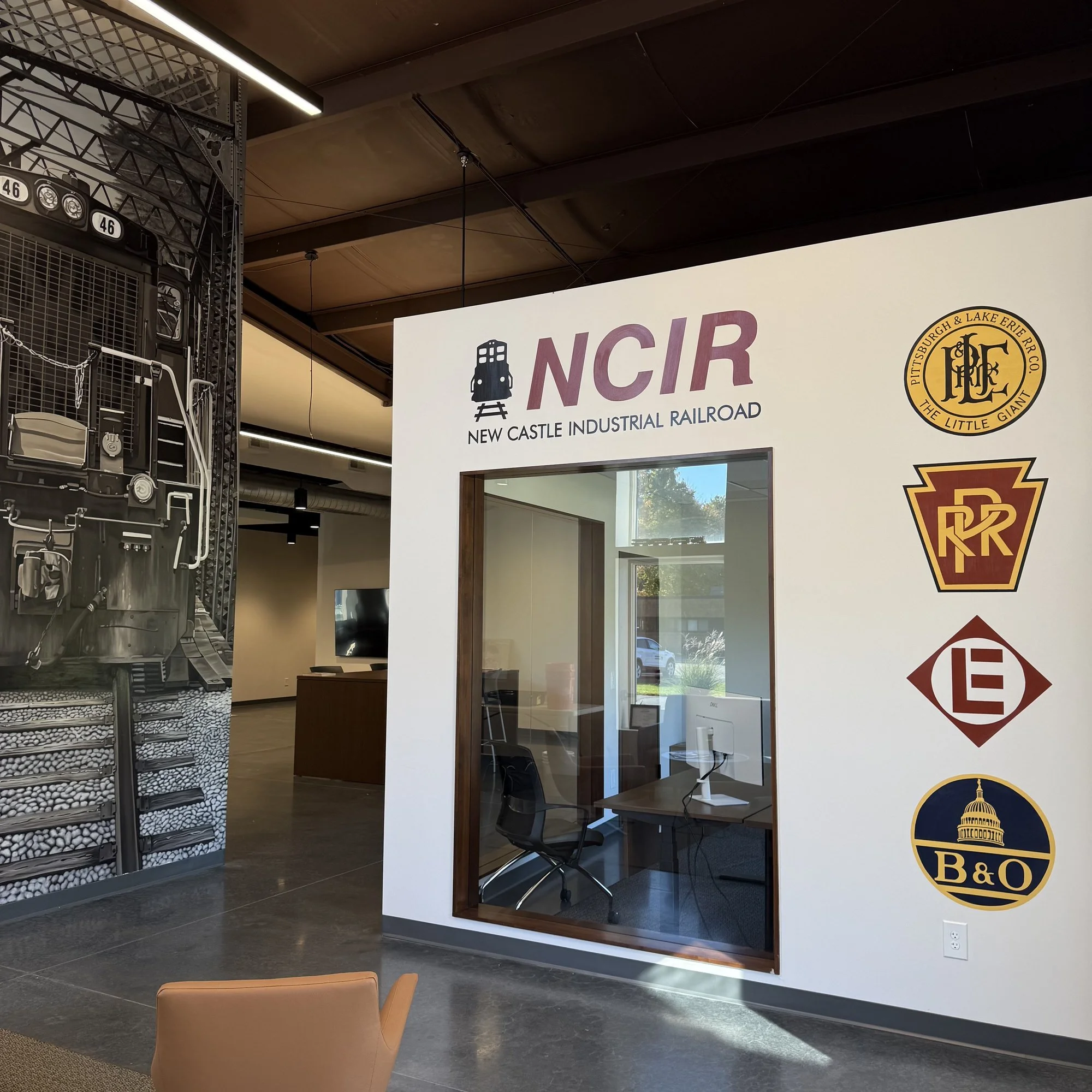 This 19' x 9' hyperrealistic mural was hand-painted in acrylic for New Castle Industrial Railroad, accompanied by the historic logos of its connecting railroads to honor the region's rich railroad heritage.