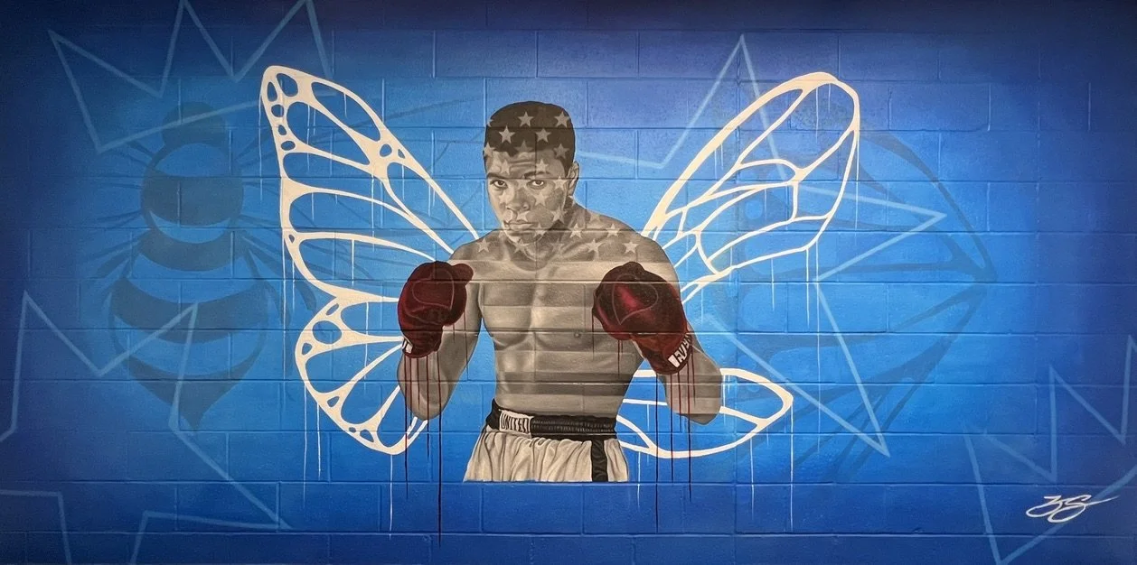 Large-scale figurative mural by Zach Slavin featuring iconic imagery and symbolic design.