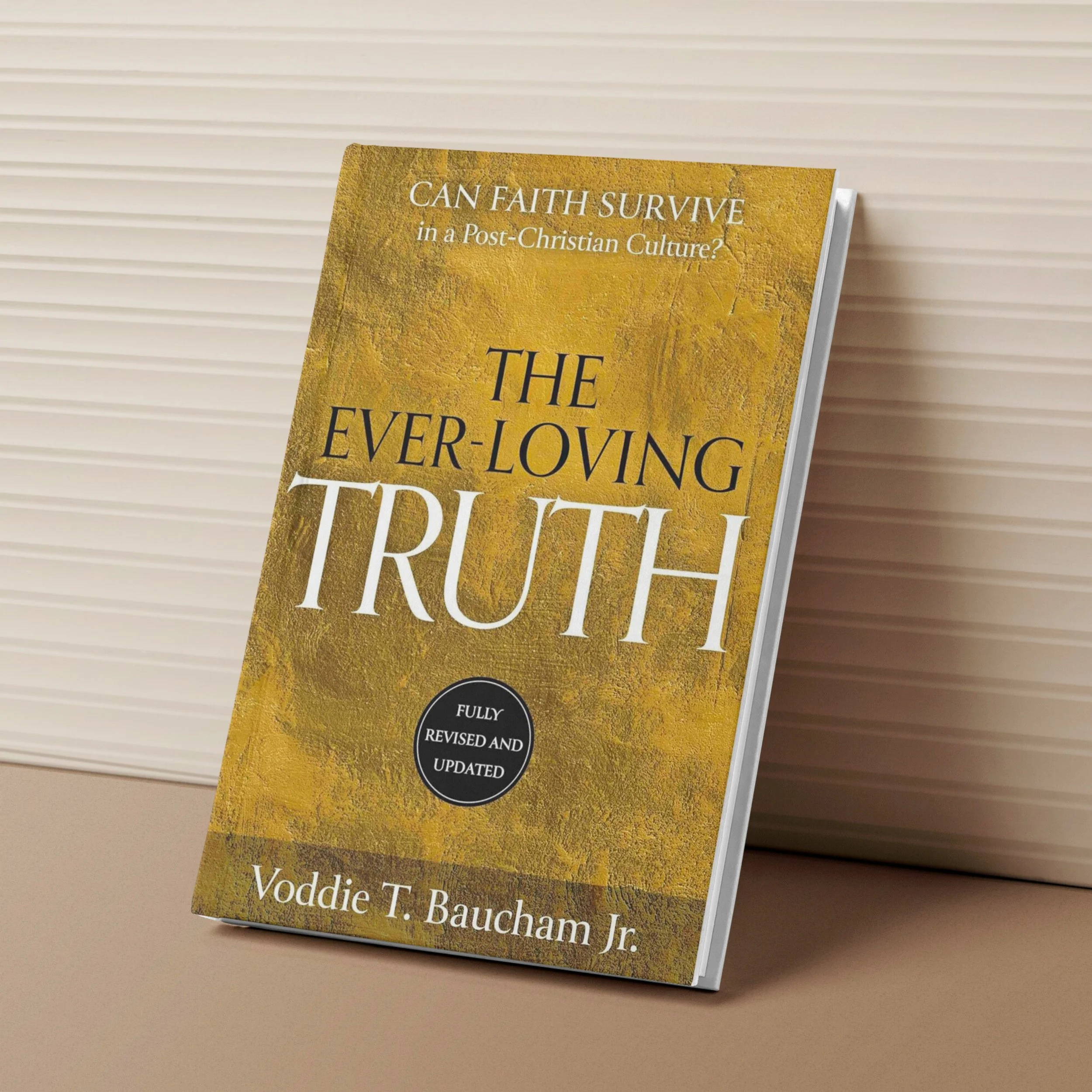 Book titled 'The Ever-Loving Truth' by Voddie T. Baucham Jr. with a yellow textured cover and white and black text, leaning against a horizontal striped white wall.