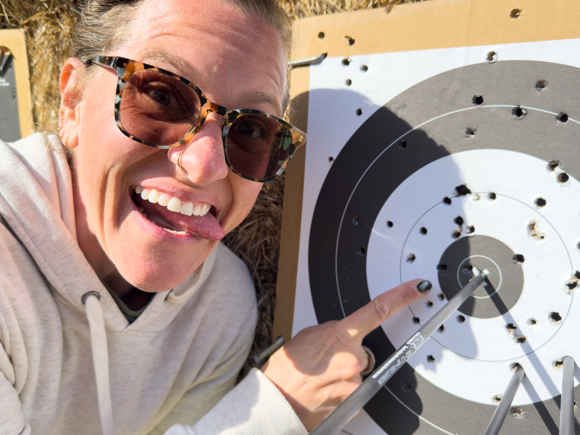 Kara pointing at an archery target bullseye