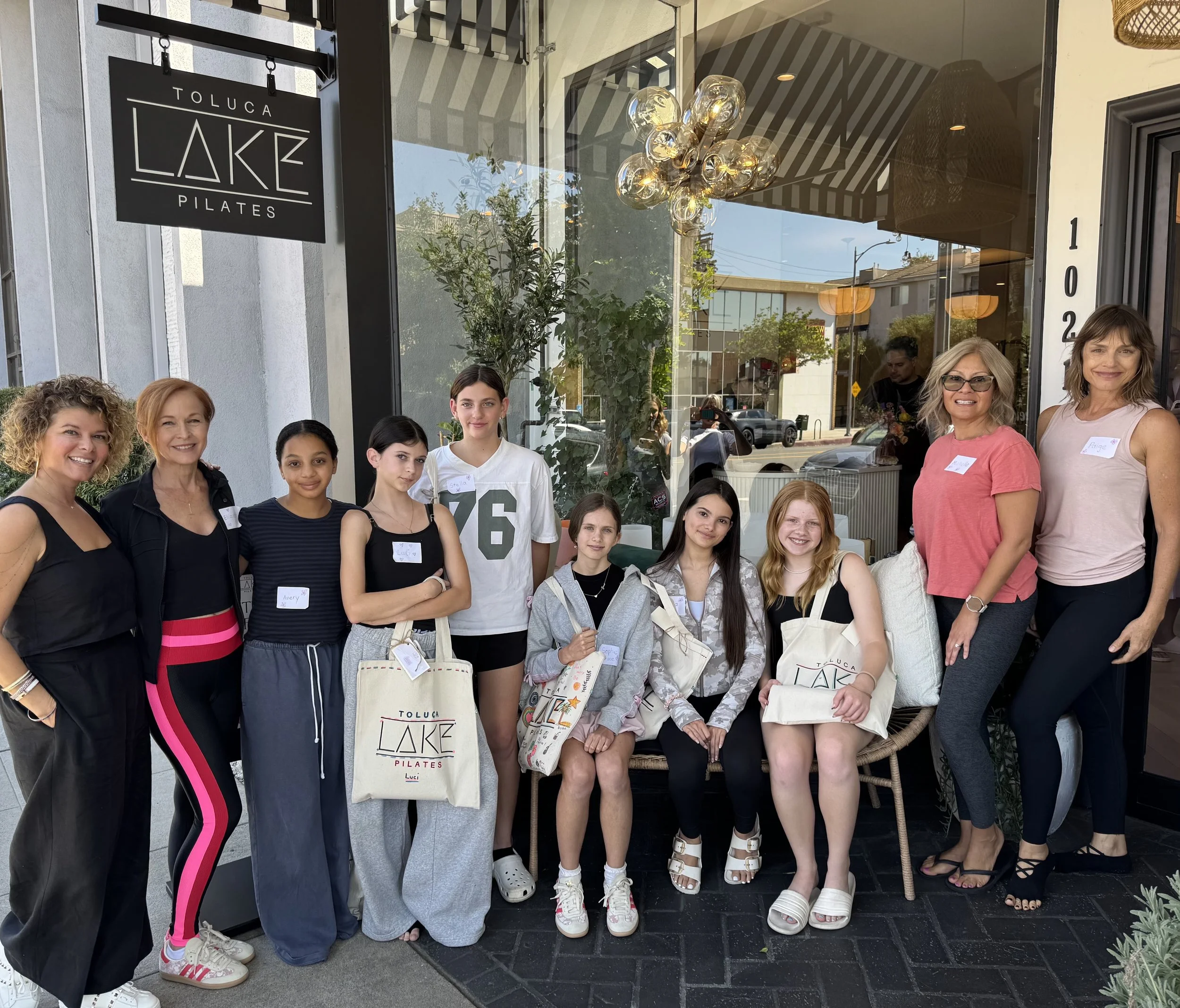 group of woman and teens in front of pilates studio