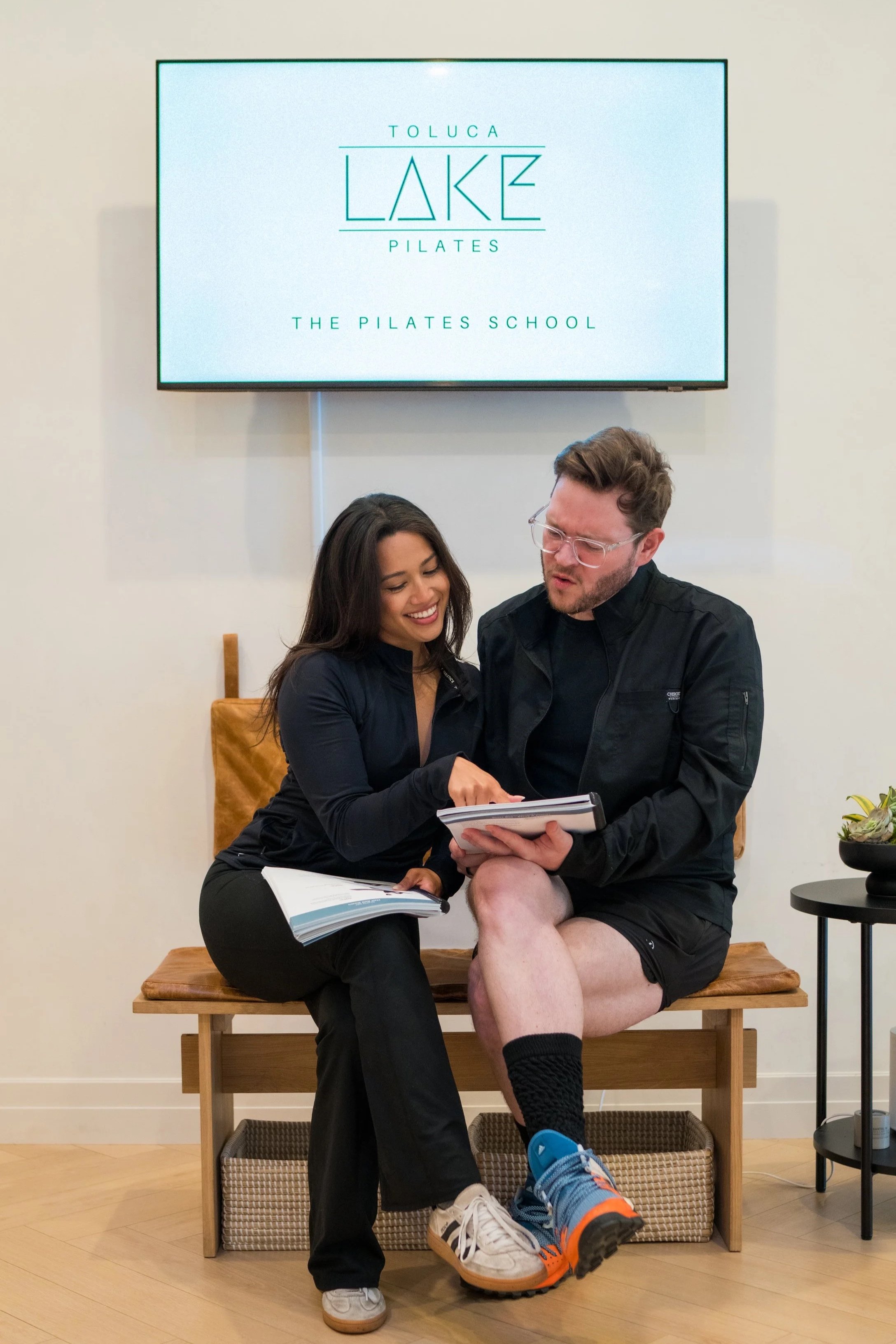 Two people discussion and reviewing pilates information